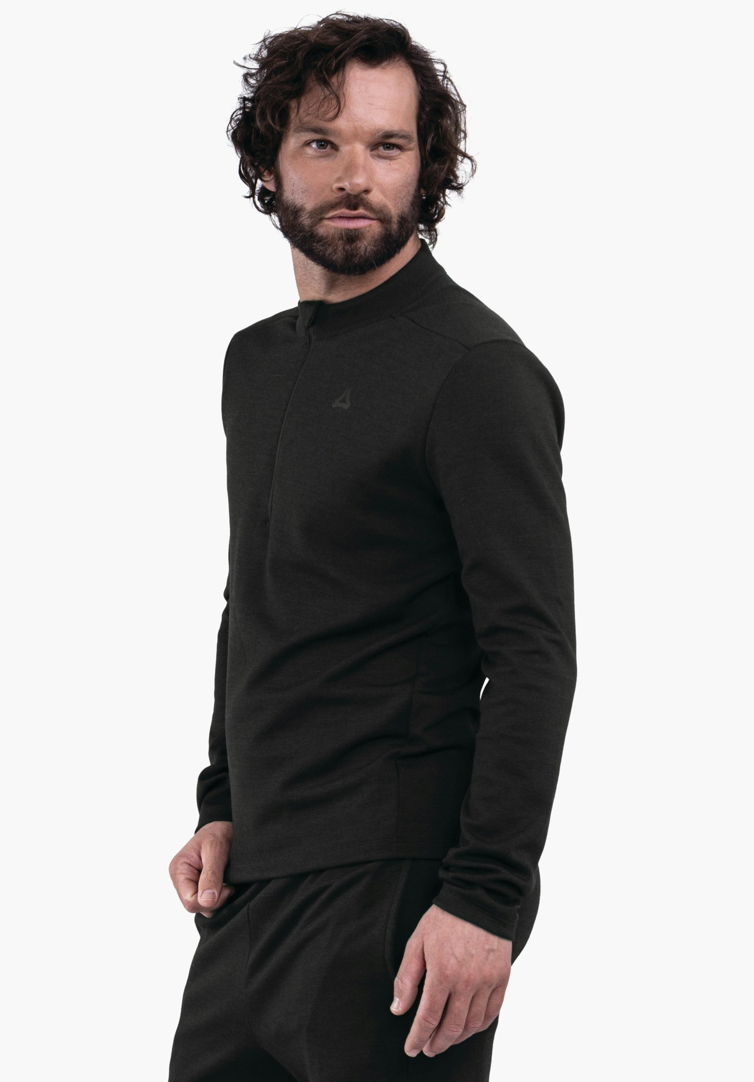 Longsleeve Style Canyfer MNS Mann in dunkelgrünem langärmligem Oberteil mit Schöffel-Logo, steht halbseitlich, schaut nach rechts, eine Hand locker an der Seite, weißer Studiohintergrund.