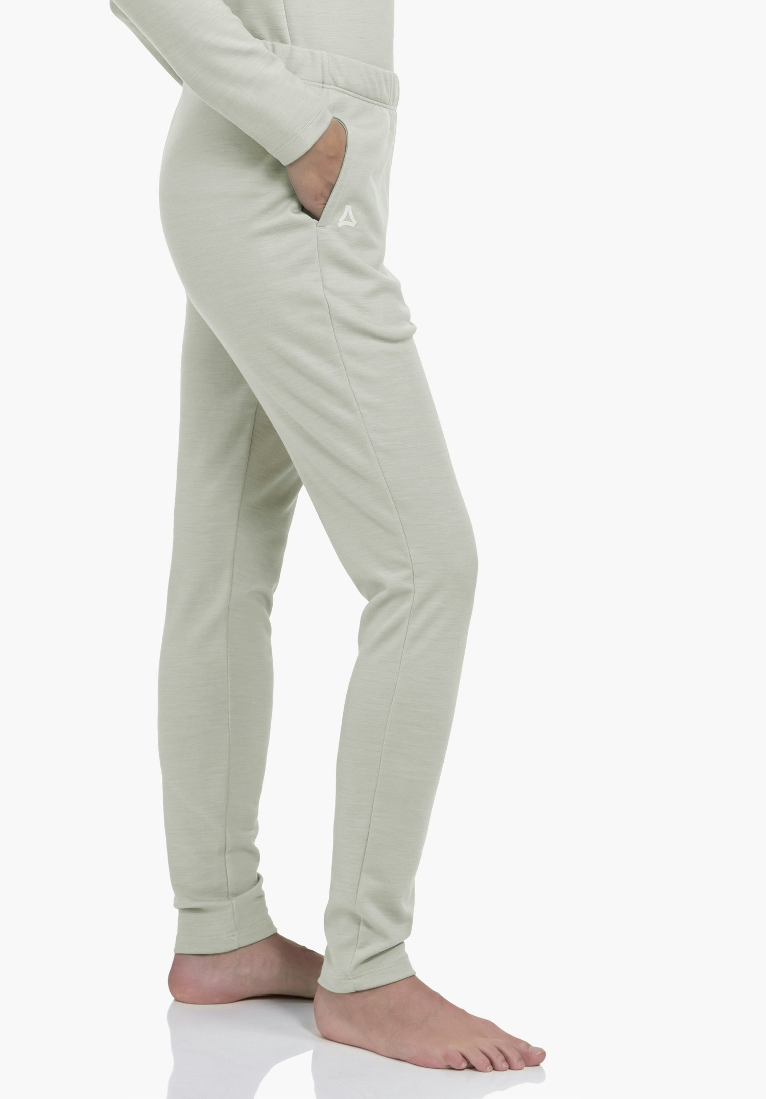 Pants Style Canyfer WMS pantalon de jogging ajusté vert clair; main dans la poche droite, petit logo Schöffel sur le côté; personne debout pieds nus sur fond studio blanc.