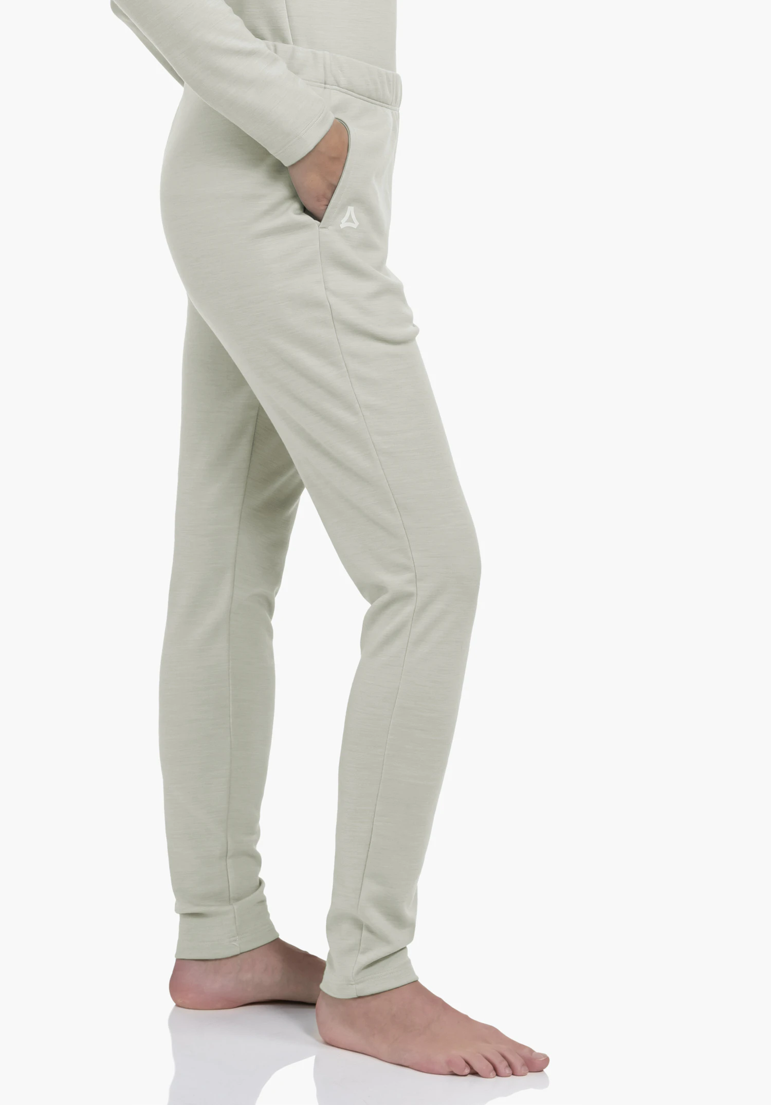 Pants Style Canyfer WMS pantalon de jogging ajusté vert clair; main dans la poche droite, petit logo Schöffel sur le côté; personne debout pieds nus sur fond studio blanc.