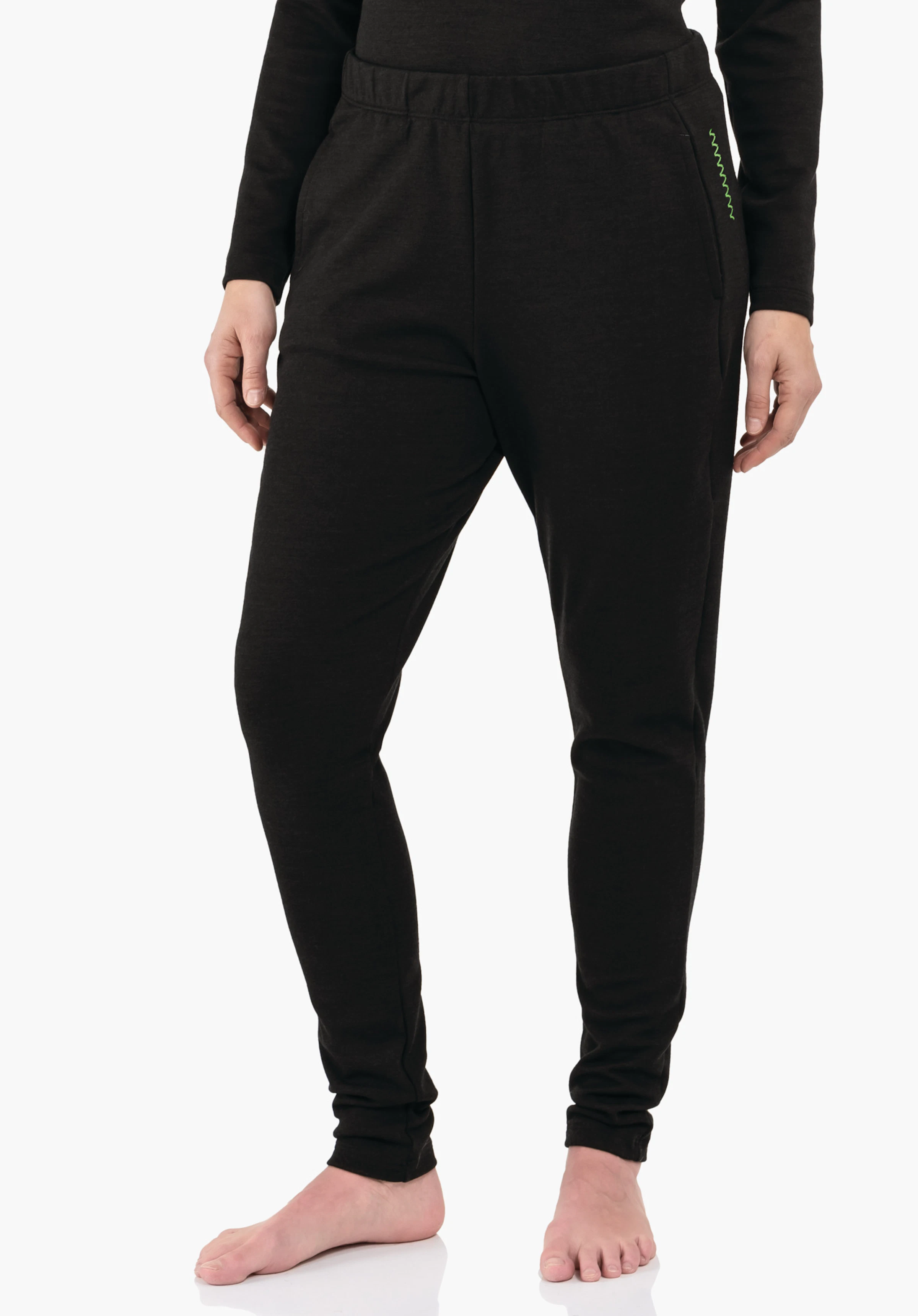 Pants Style Canyfer WMS Pantalon de jogging noir foncé porté par une personne debout, mains le long du corps, pieds nus sur fond studio clair; poignets élastiques fins et poches latérales avec couture décorative verte.
