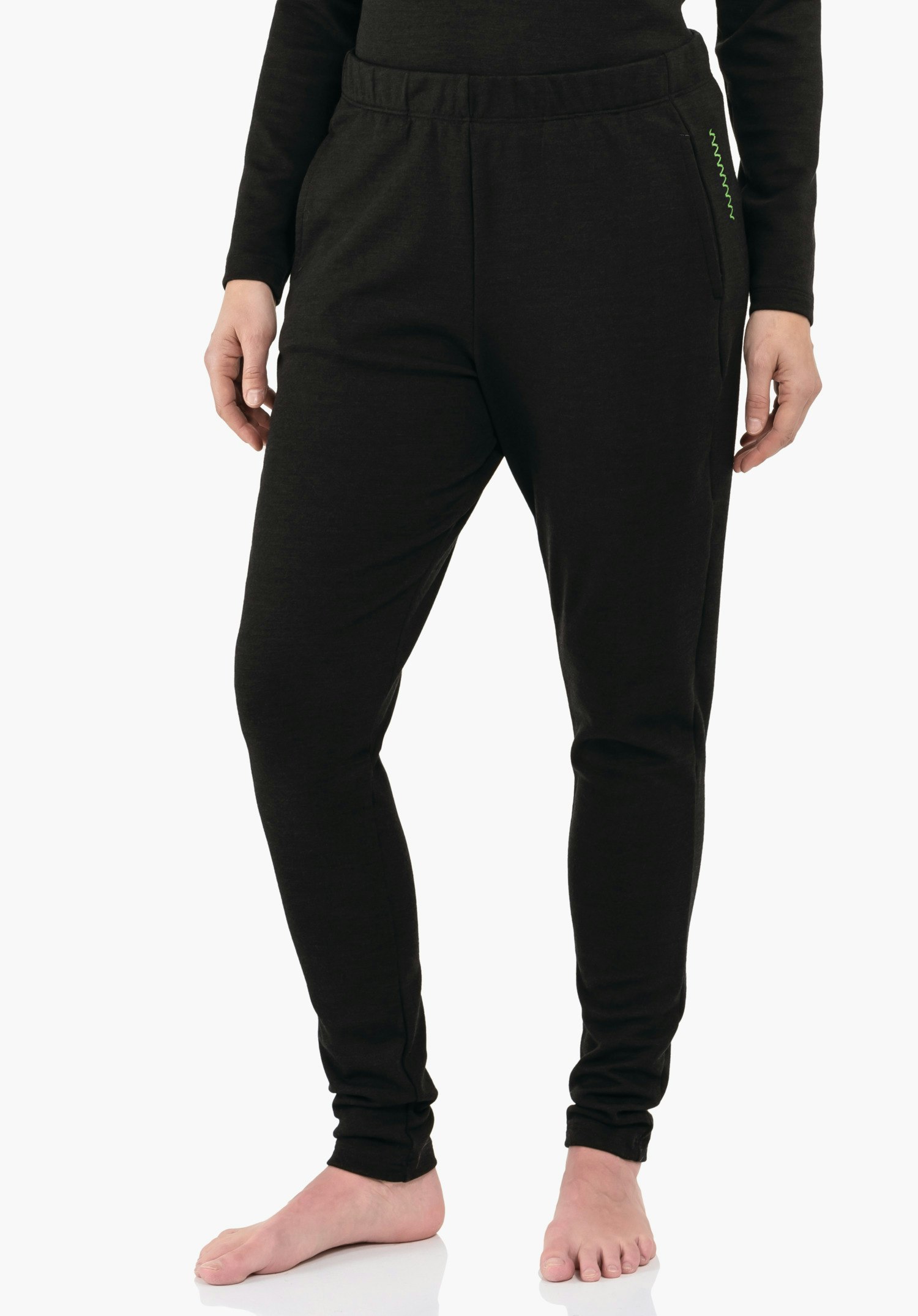 Pants Style Canyfer WMS Pantalon de jogging noir foncé porté par une personne debout, mains le long du corps, pieds nus sur fond studio clair; poignets élastiques fins et poches latérales avec couture décorative verte.