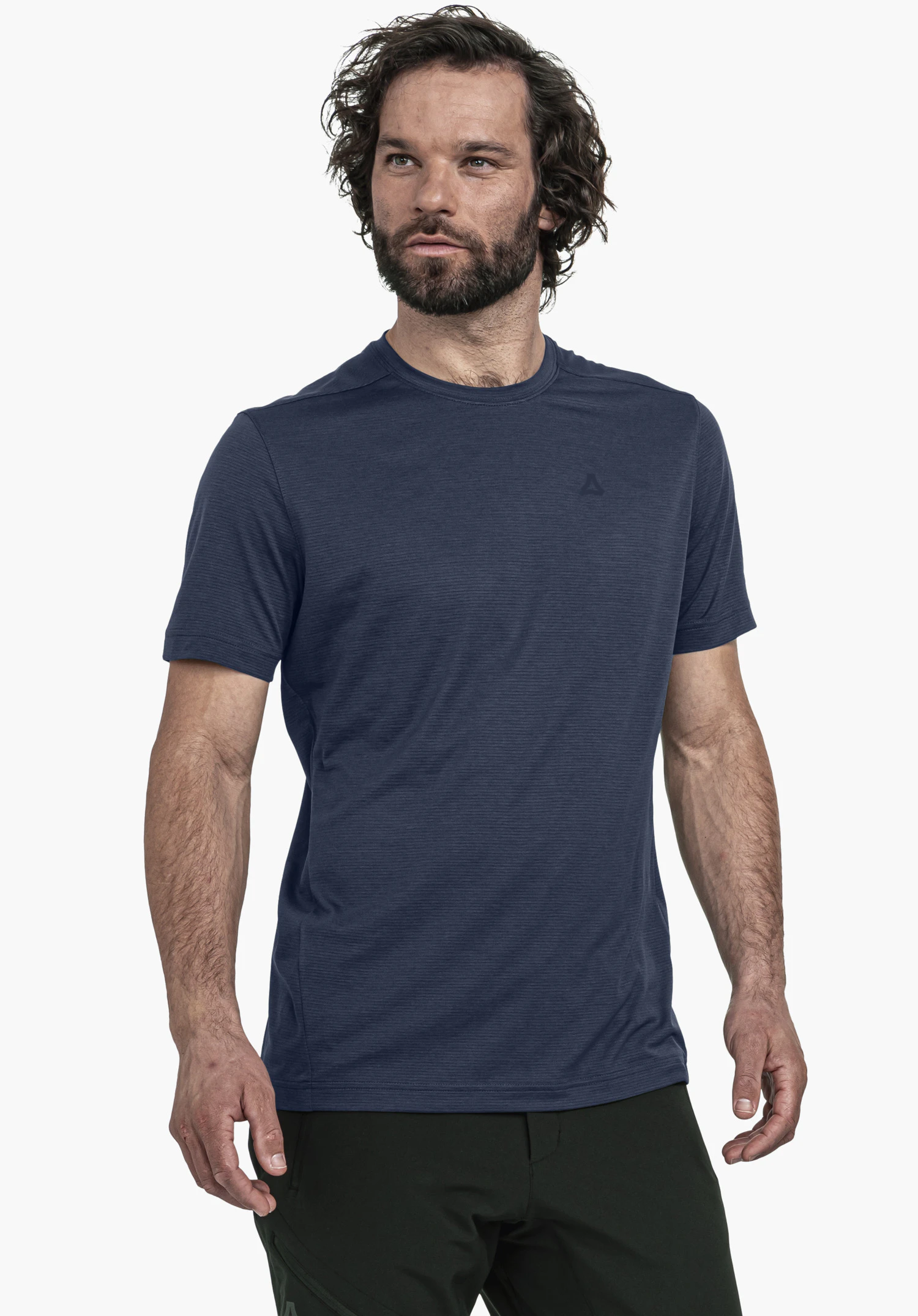 T Shirt Style Chipoma MEN in blauw: Het model staat frontaal en licht gedraaid voor een neutrale achtergrond. Het shirt valt op door de subtiele textuur en het kleine, ton-sur-ton Schöffel-logo op de borst.