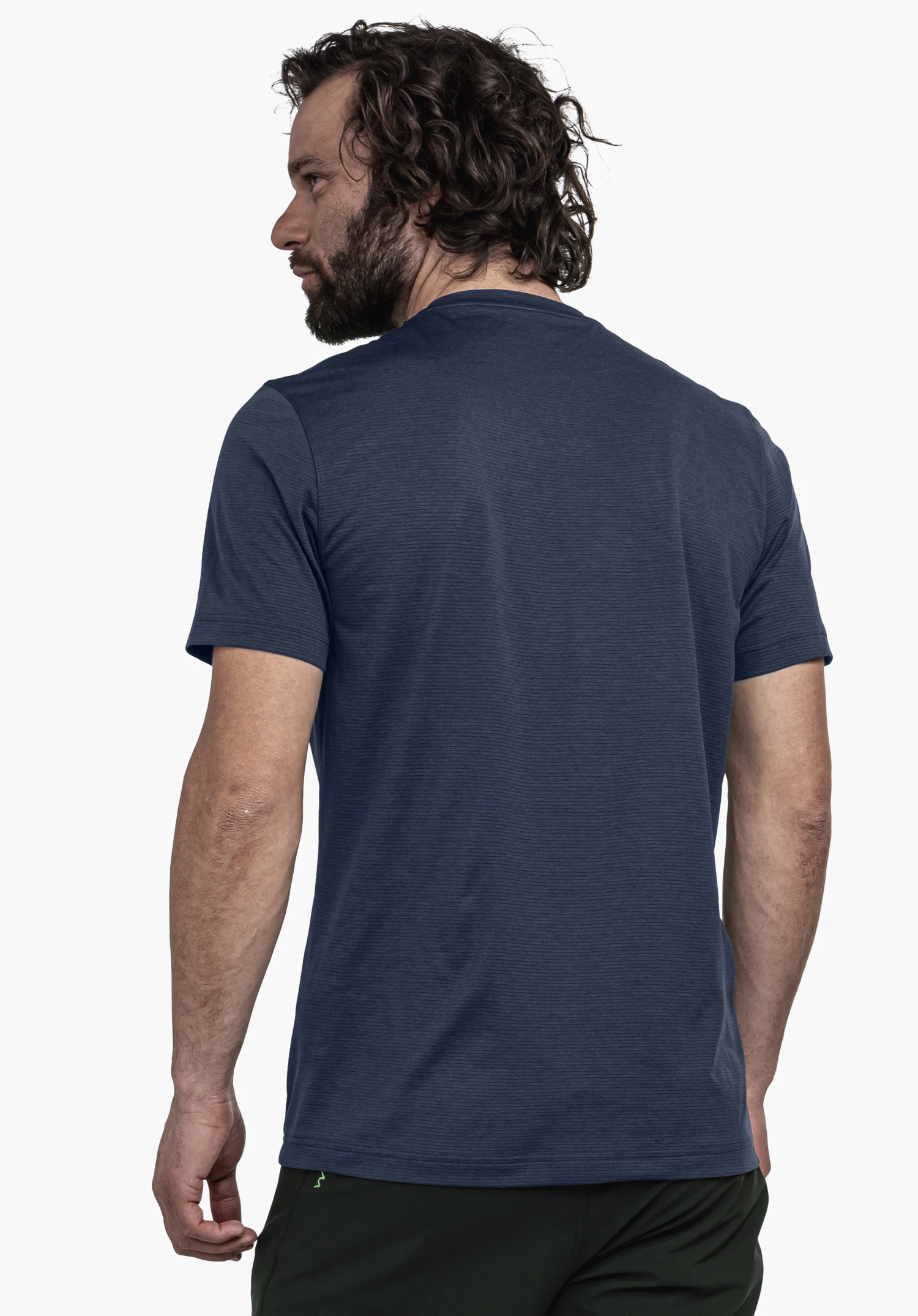 T Shirt Style Chipoma MEN in het blauw, gefotografeerd vanaf de achterkant tegen een neutrale achtergrond. Het model draagt het shirt en kijkt opzij, waarbij het kleine, groene Schöffel-logo aan de onderzijde zichtbaar is.