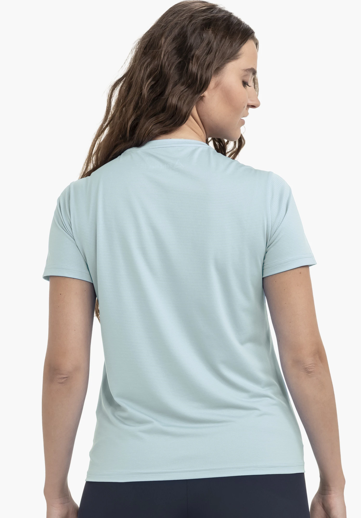 T Shirt Style Chipoma WMN in Blau: Eine Frau ist in der Rückenansicht zu sehen, wobei das dezent strukturierte Design des T-Shirts im Fokus steht. Das dezente Schöffel-Logo im Nackenbereich ist erkennbar. Das Model ist vor einem neutralen Hintergrund platziert.