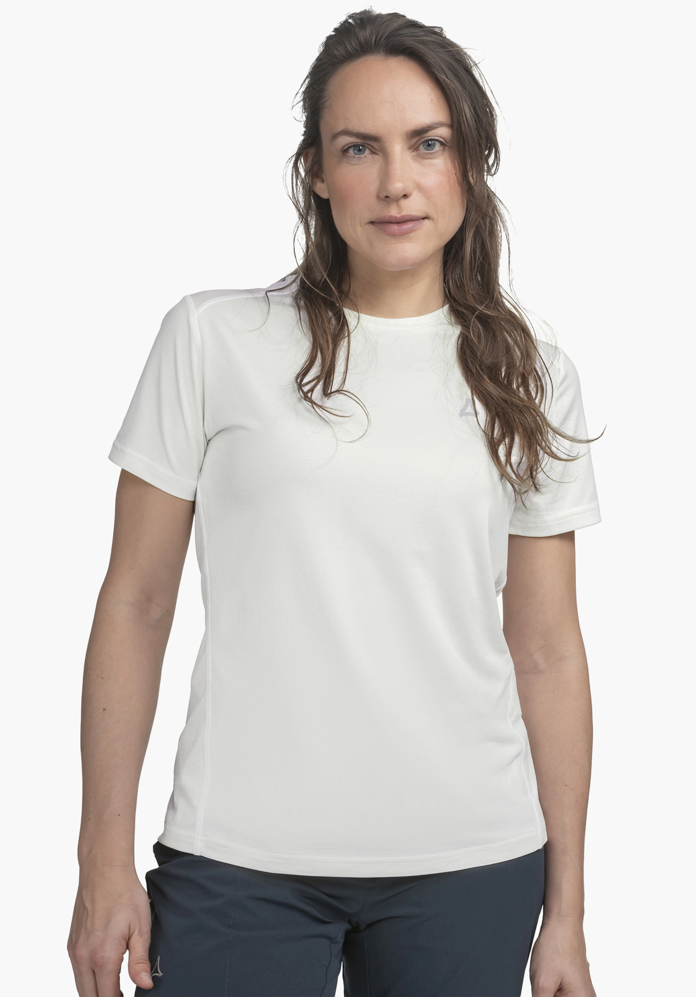 T Shirt Style Chipoma WMN : Le mannequin pose de face sur un fond neutre, mettant en valeur le t-shirt de couleur blanche. Le logo Schöffel discret au niveau de la poitrine souligne le style sportif pour la saison à venir.