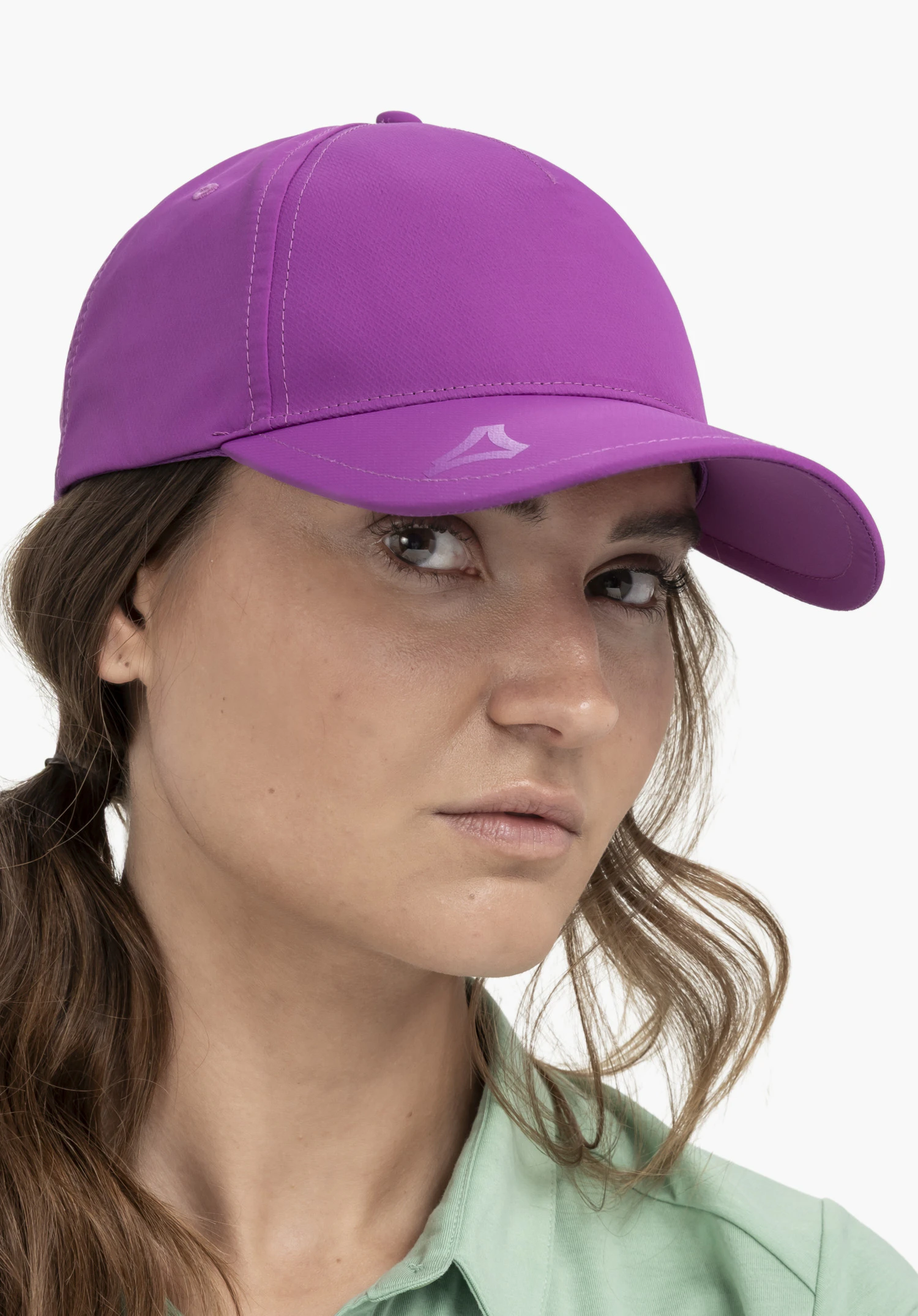 Cap Style Dooser UNI worn by a model in a close-up shot. The model is looking directly at the camera. The pink cap features the Schöffel logo on the peak, photographed against a neutral background.