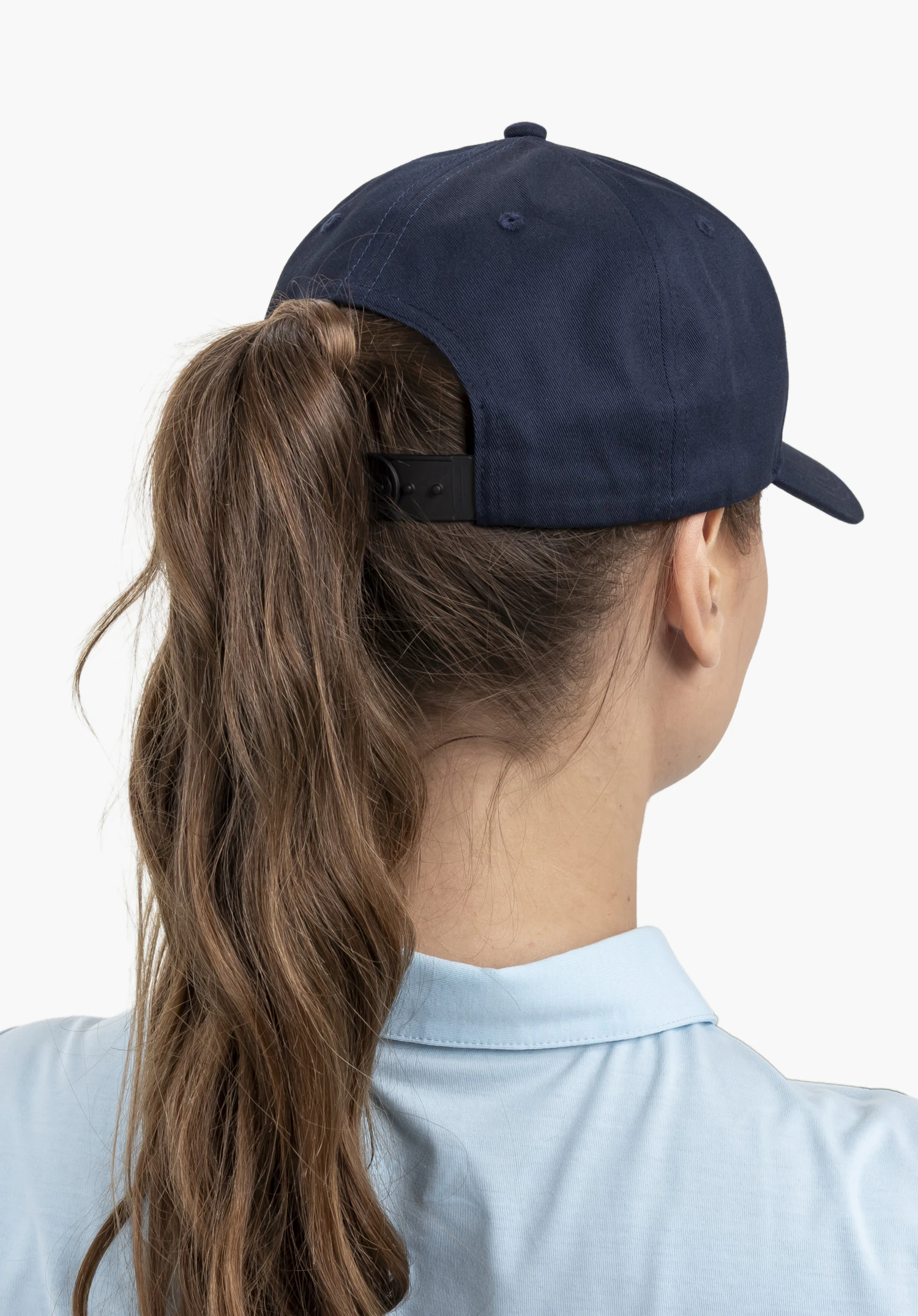 Cap Style Collada UNI in blue: This rear view features the model with a ponytail against a neutral background. The cap in a rich blue hue offers adjustable sizing and complements a sporty look.