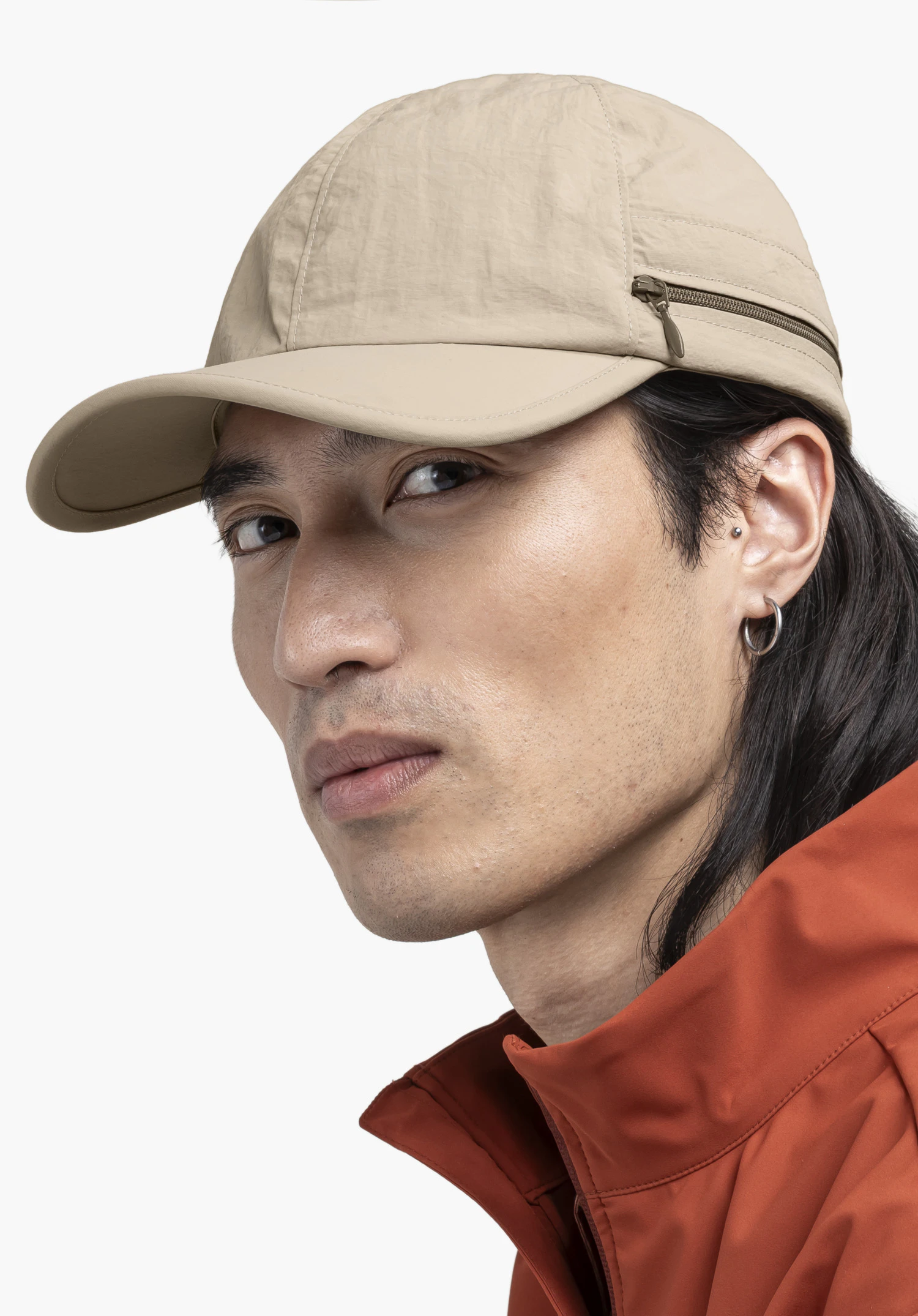 Cap Style Dalfoss UNI en beige, portée par un mannequin qui tourne la tête vers l'objectif dans une vue de profil, photographiée devant un fond neutre.
