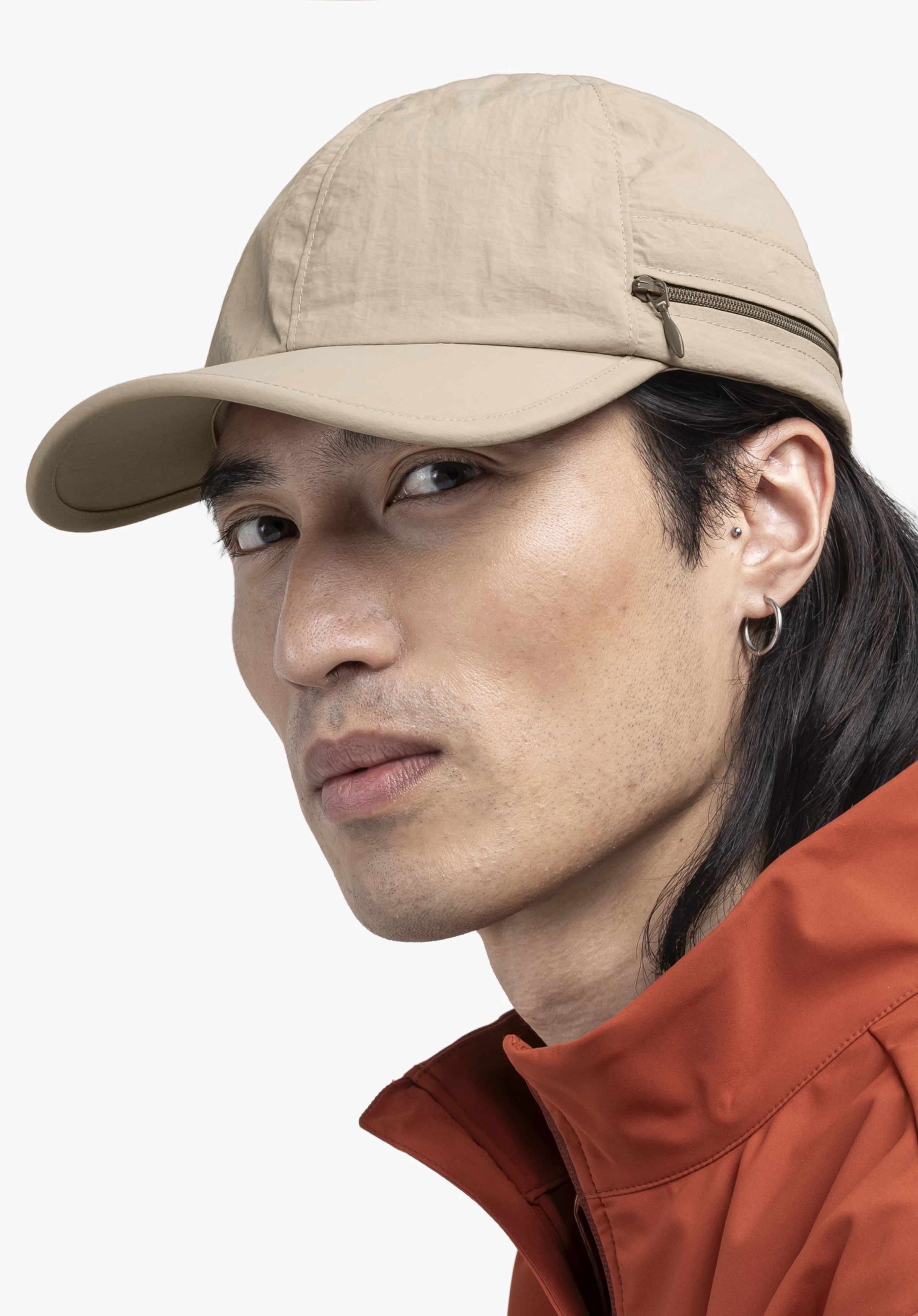 Cap Style Dalfoss UNI en beige, portée par un mannequin qui tourne la tête vers l'objectif dans une vue de profil, photographiée devant un fond neutre.