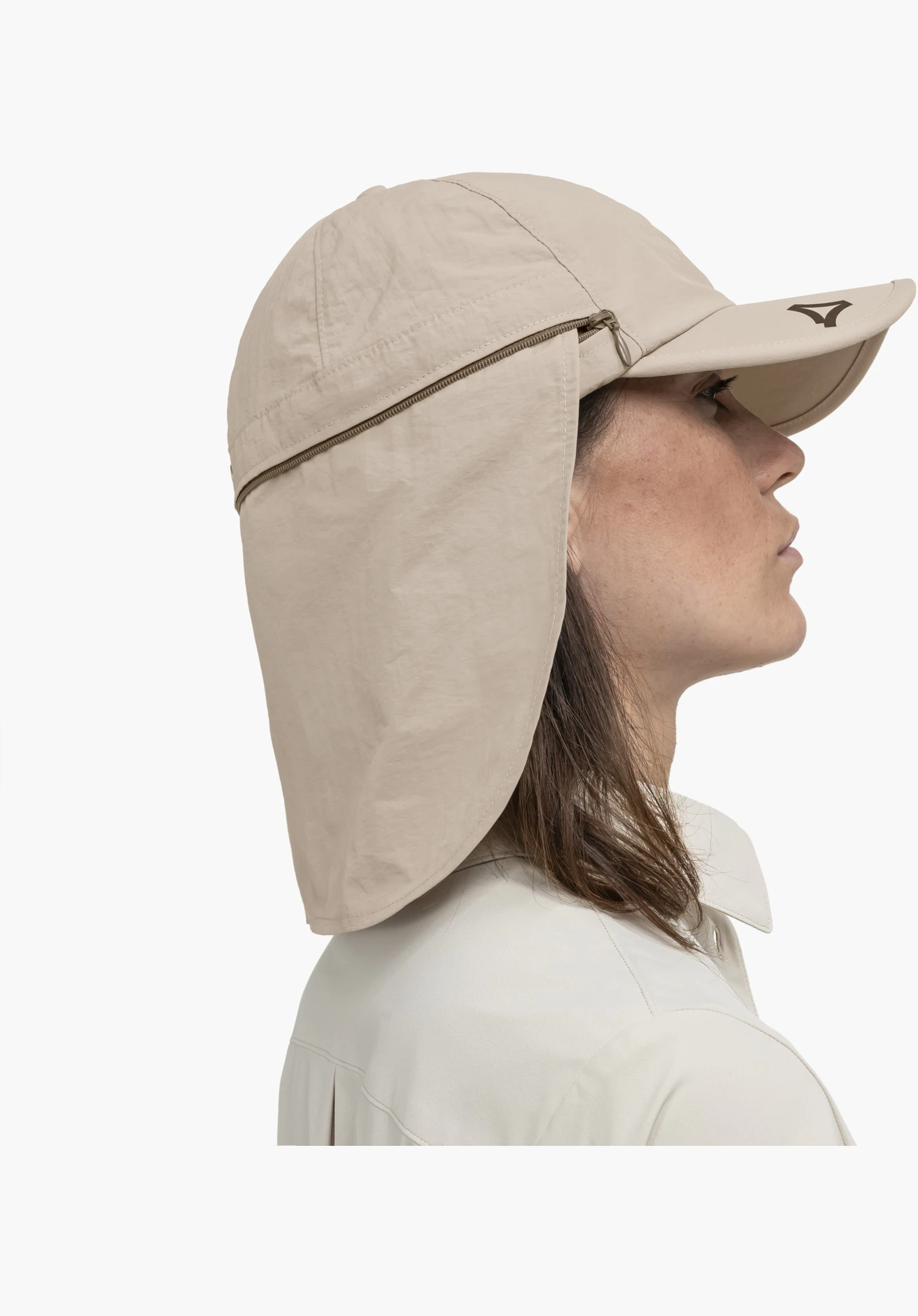 Cap Style Dalfoss UNI présente la fermeture éclair circulaire pour fixer le protège-nuque et le logo Schöffel sur la visière beige, gros plan sur fond blanc.