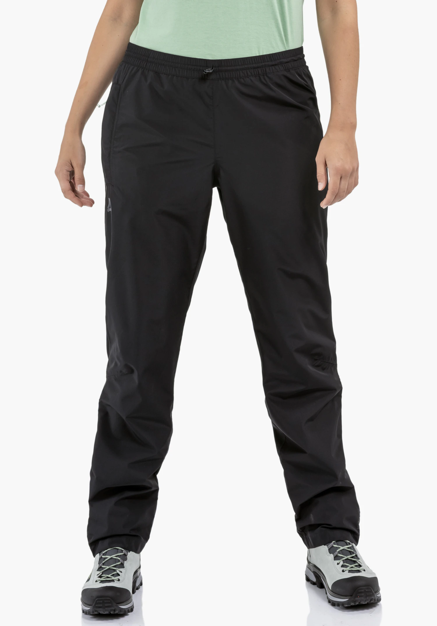 Rain Pants Style Elmori UNI, focusing on the elasticated waistband and the smooth black fabric with the subtle Schöffel-Logo on the leg, in a close-up against a white background.