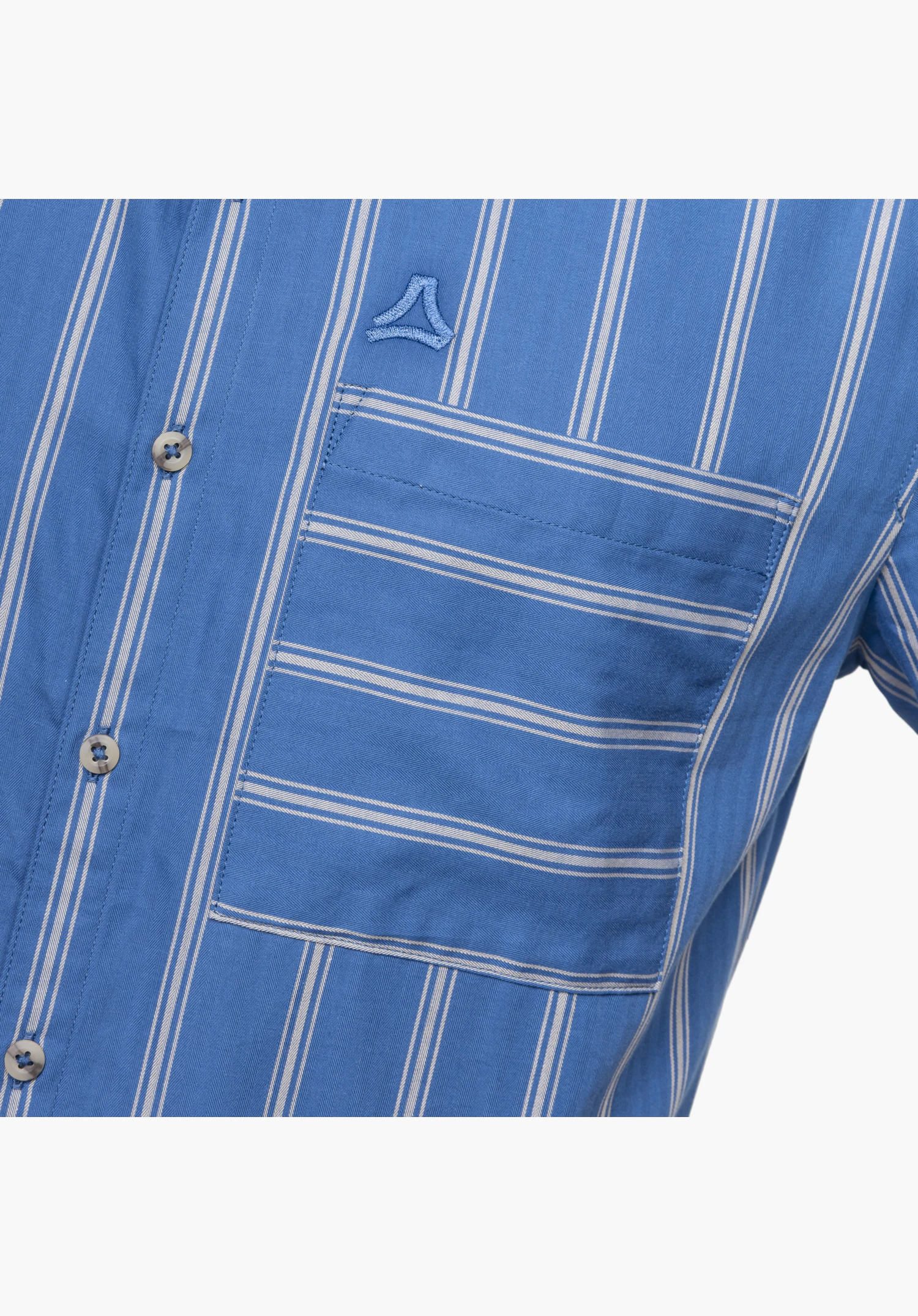 Shirt Style Kalmen MEN zeigt die blaue Stoffstruktur mit Streifenmuster, eine Brusttasche mit horizontal verlaufenden Streifen, Knöpfe und das gestickte Schöffel-Logo. Nahaufnahme vor weißem/neutralem Hintergrund.