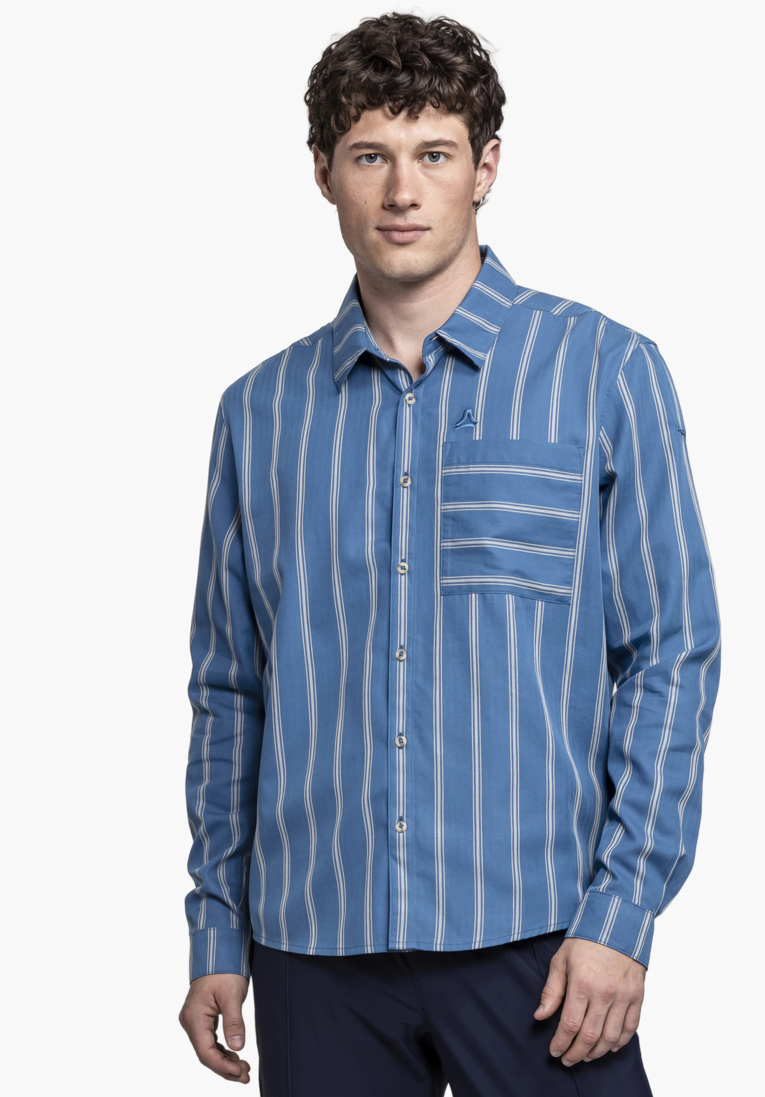 Shirt Style Chanduy MEN in blue is showcased by a model standing facing the camera. Set against a neutral background, the striped design is clearly visible, with the subtle Schöffel logo on the chest pocket adding a refined touch.