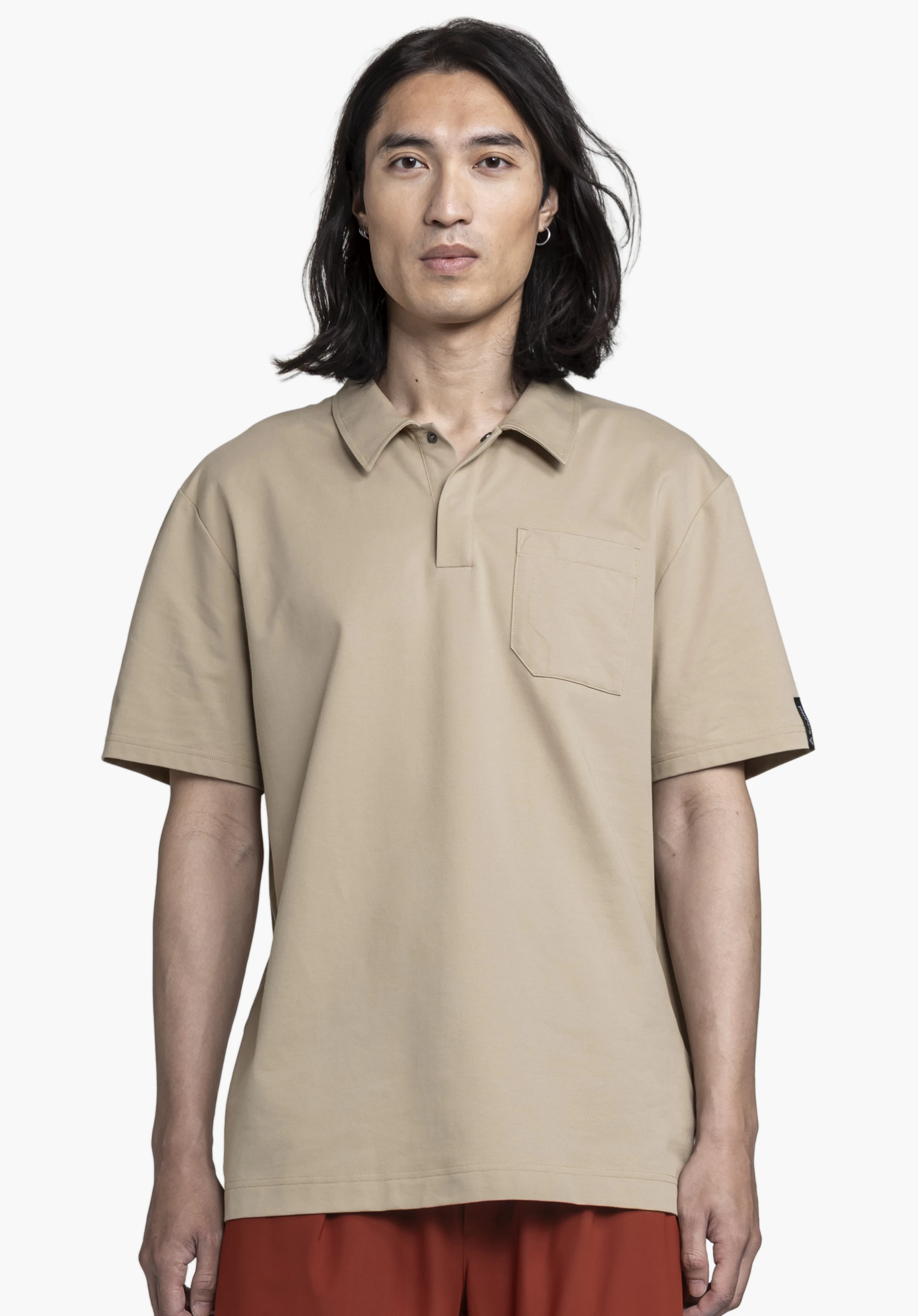 Polo Shirt Style Serenio MEN is shown in an elegant beige color against a neutral background. A male model stands front-facing, wearing the polo shirt which features the subtle Schöffel logo on the sleeve.