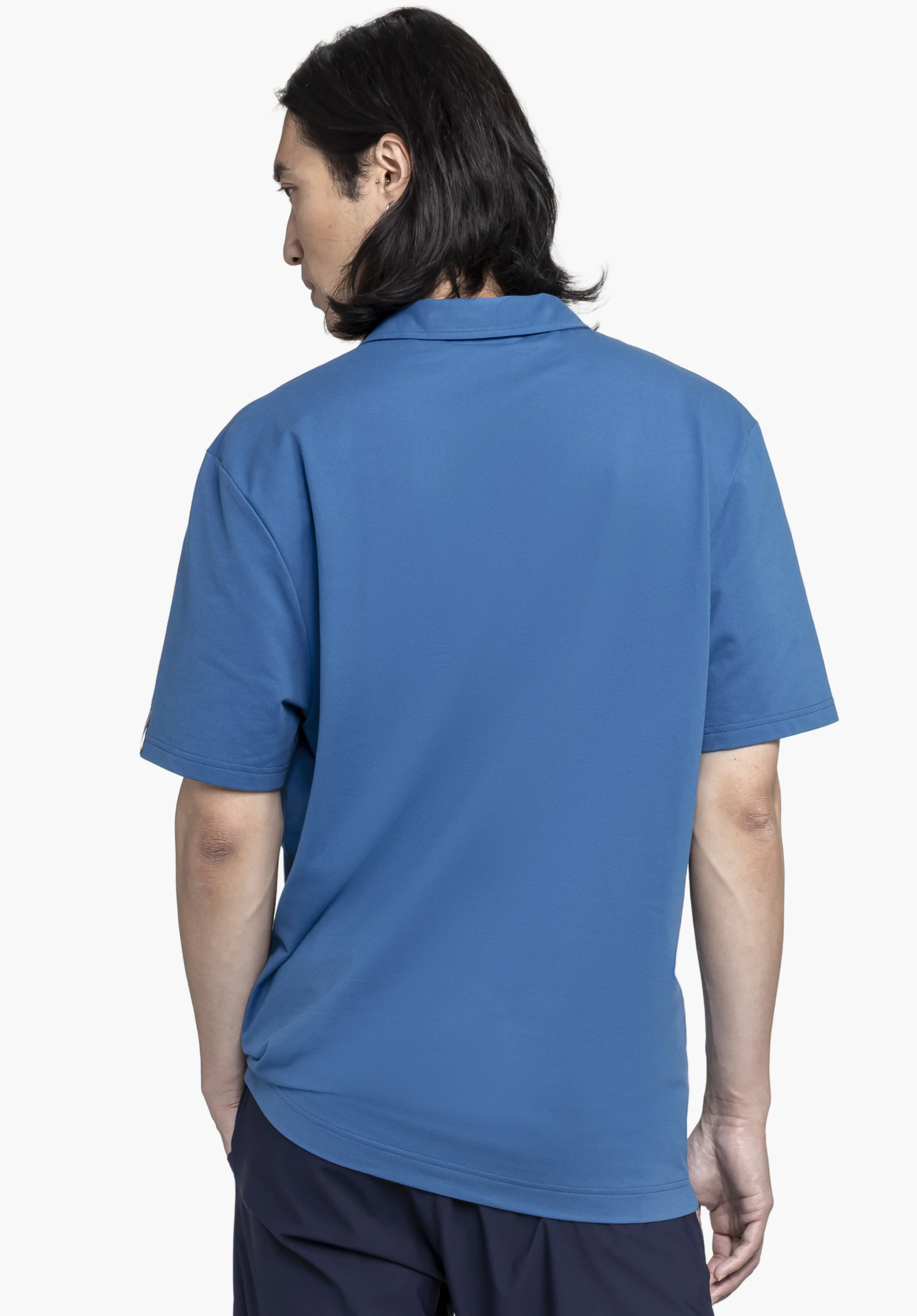 Polo Shirt Style Serenio MEN in blue. A model shows the shirt from a back view against a neutral background. The high-quality fabric and fit are perfectly highlighted by this clean perspective.