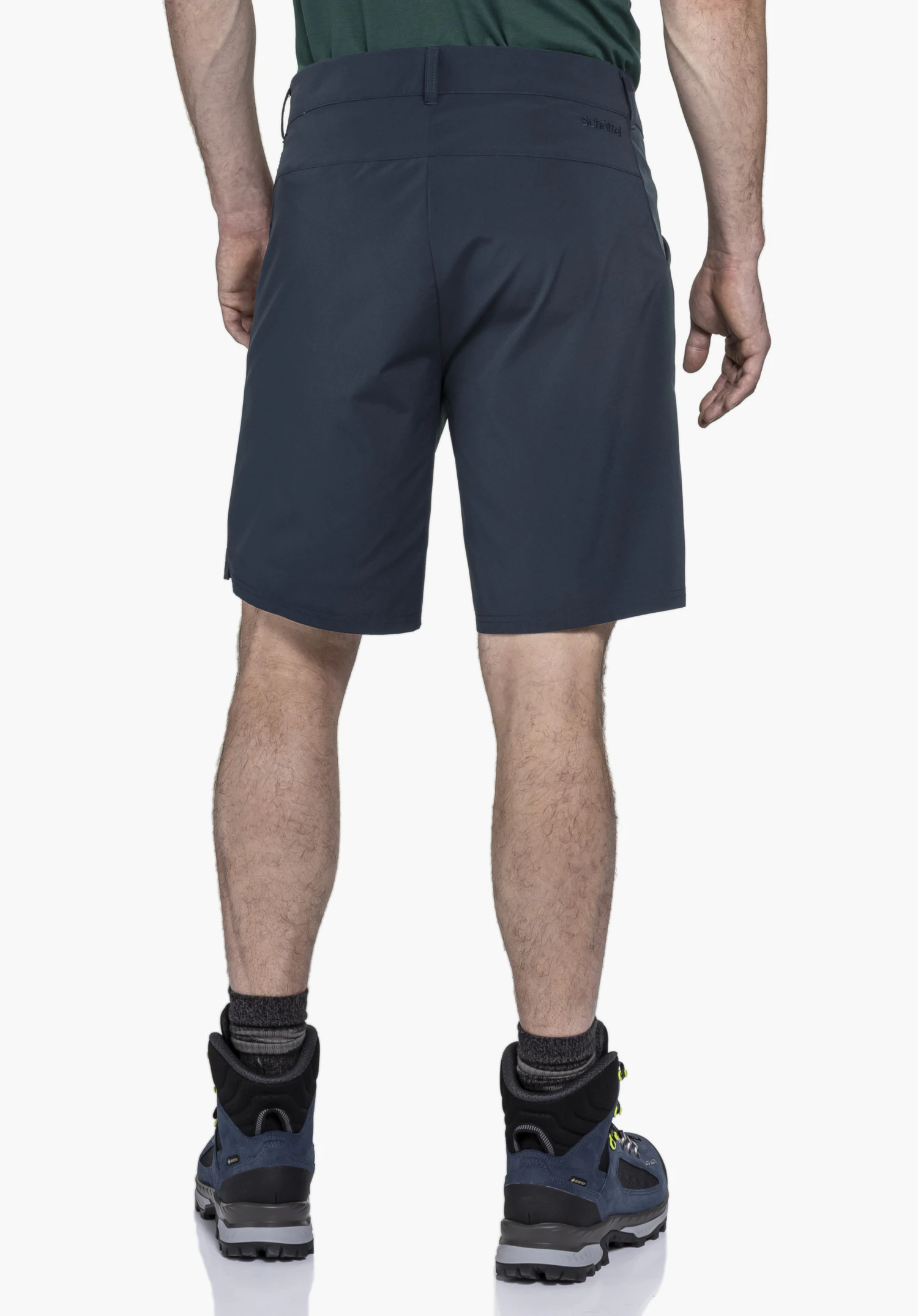 CIRC Shorts Style Smue MEN on a model in a back view. The blue shorts feature a subtle Schöffel logo on the right rear side and are presented with hiking boots against a neutral background.