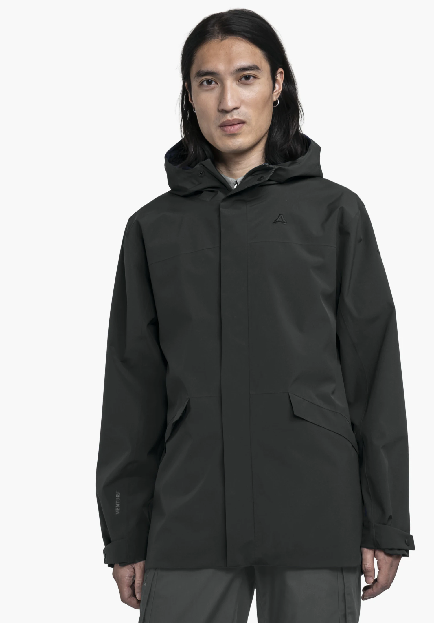 CIRC Jacket Style Smue MEN in black. A model stands facing forward wearing the closed jacket with a hood. The Schöffel logo is visible on the left chest. The image shows the garment against a neutral background.