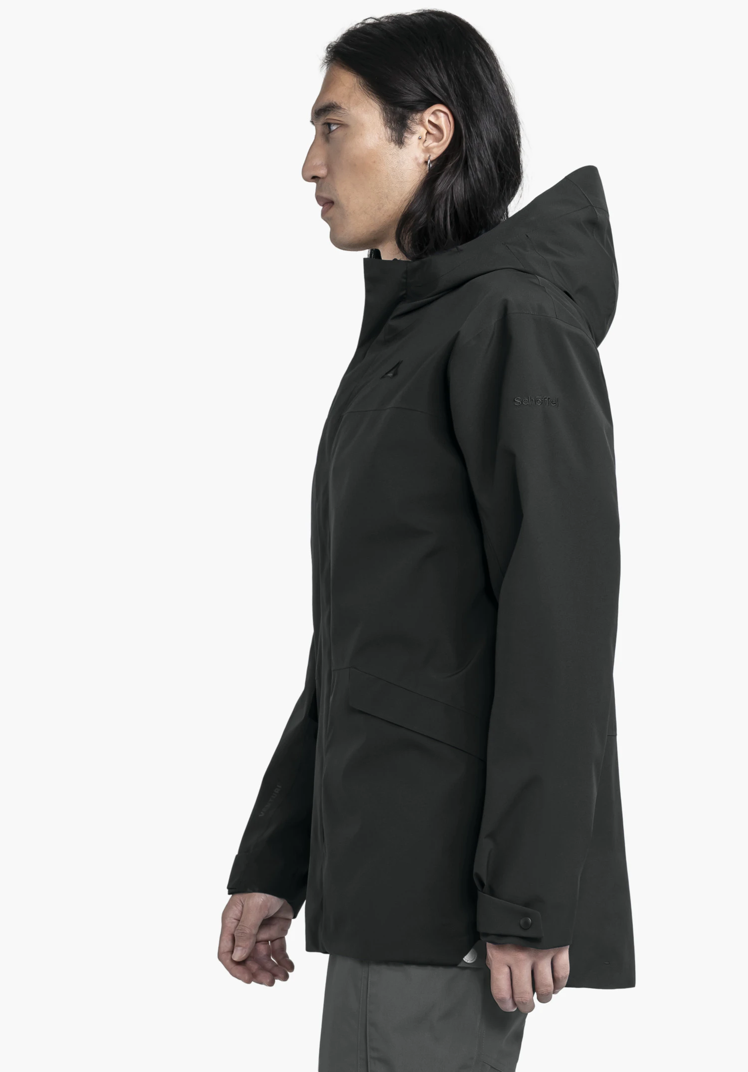 CIRC Jacket Style Smue MEN in timeless black. The model stands in profile against a neutral background, highlighting the jacket's sleek silhouette and the subtly placed Schöffel logo on the sleeve.
