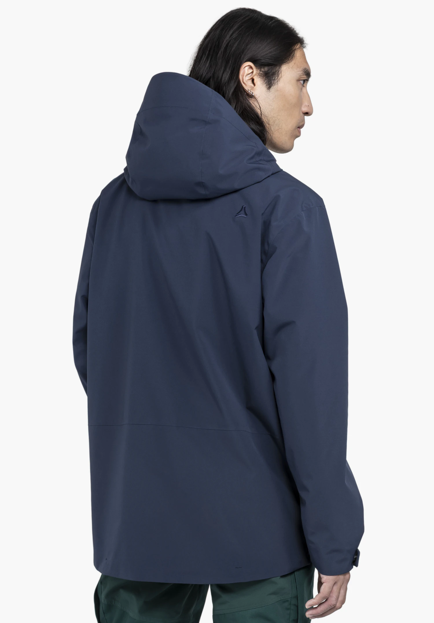 CIRC Jacket Style Smue MEN worn by a model in a back view. The model is standing slightly turned to the side in the blue hooded jacket, featuring the Schöffel logo on the right shoulder area, against a neutral background.