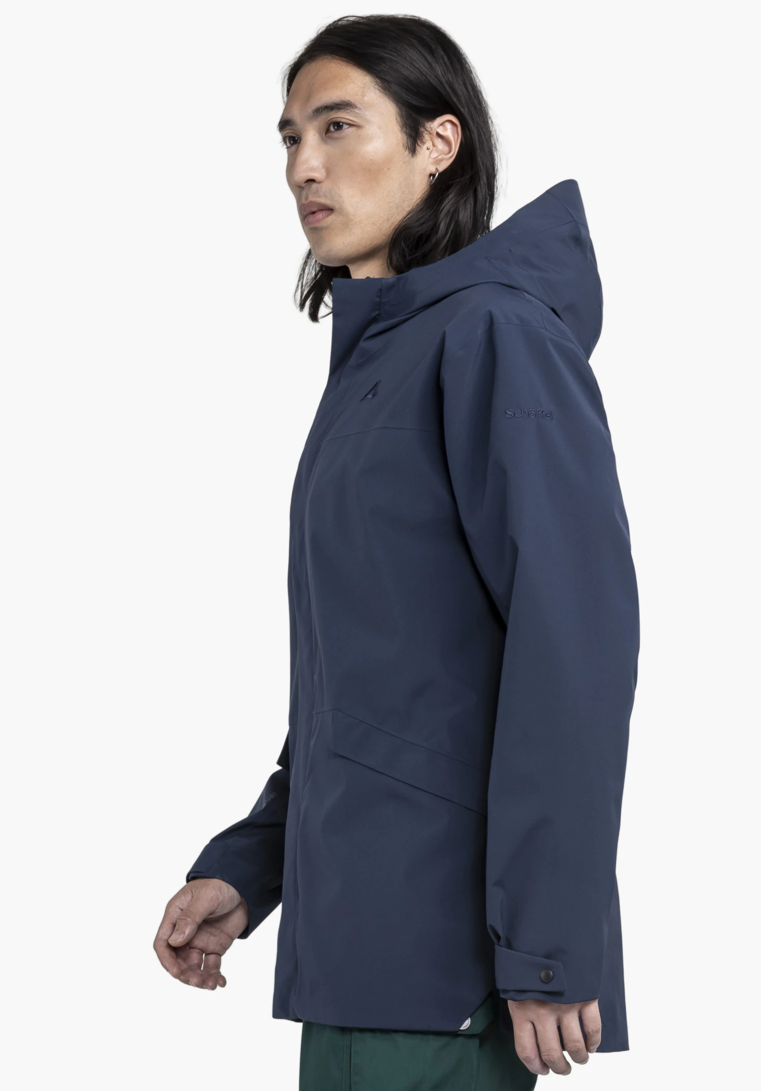 CIRC Jacket Style Smue MEN in blue worn by a model standing in a side profile. Against a neutral background, the subtly placed Schöffel logo on the upper arm and the functional cut of the jacket are clearly visible.