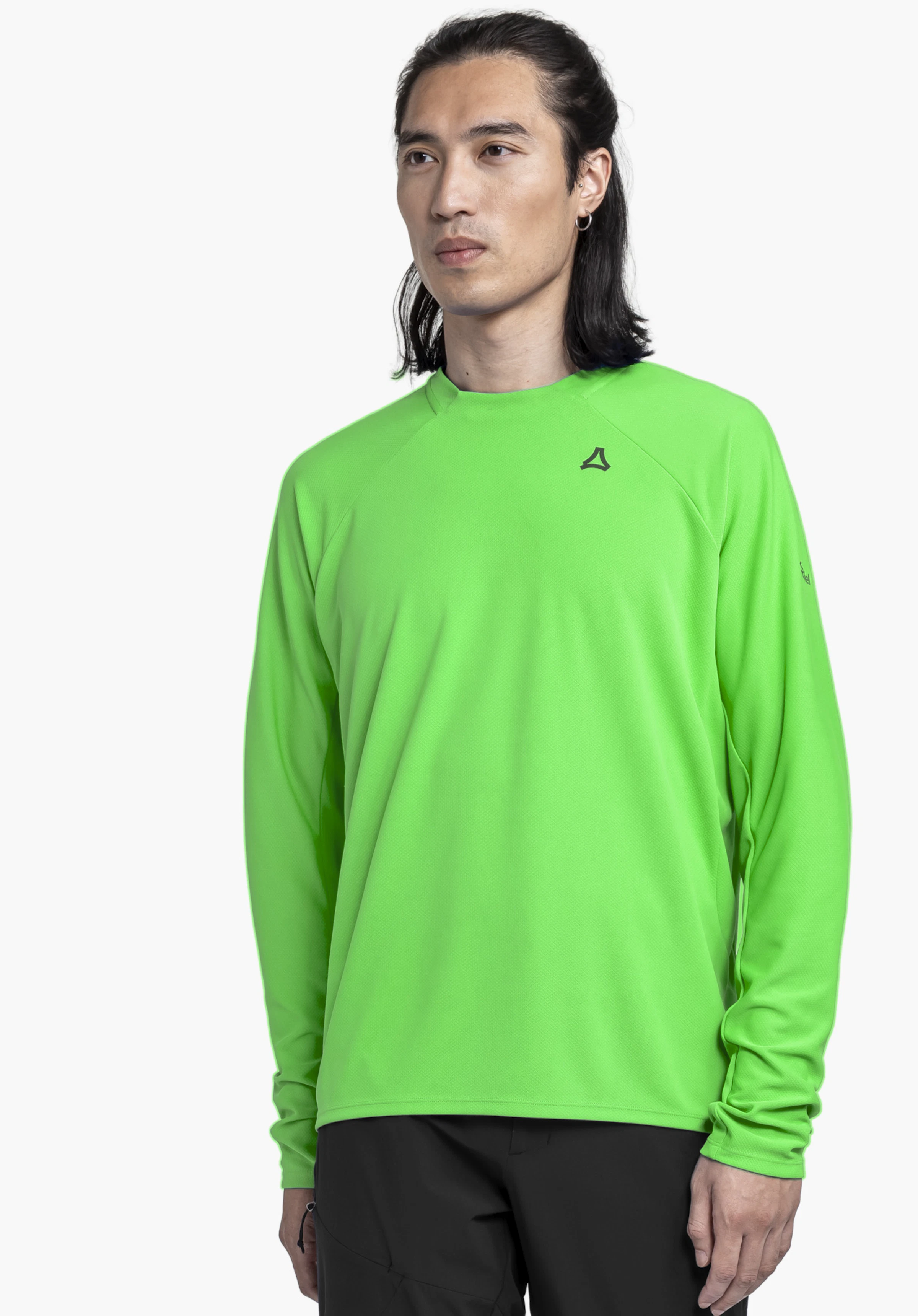 Longsleeve Style Enixa MEN worn by a model standing slightly sideways. The green shirt features the Schöffel logo on the left chest, photographed against a neutral background.