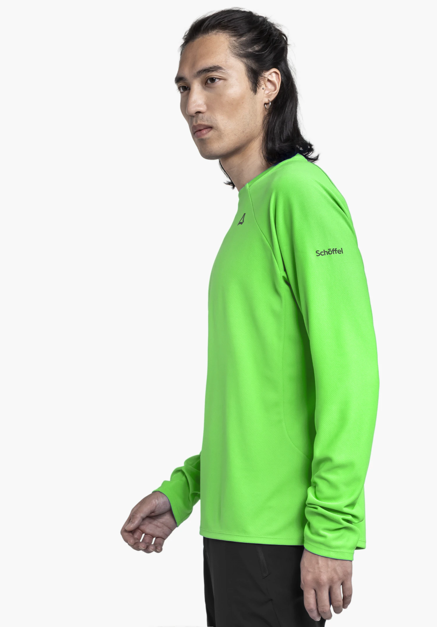 Longsleeve Style Enixa MEN in vibrant green. A model stands in a side profile view against a neutral background, showcasing the long sleeve top with the Schöffel logo visible on the arm.