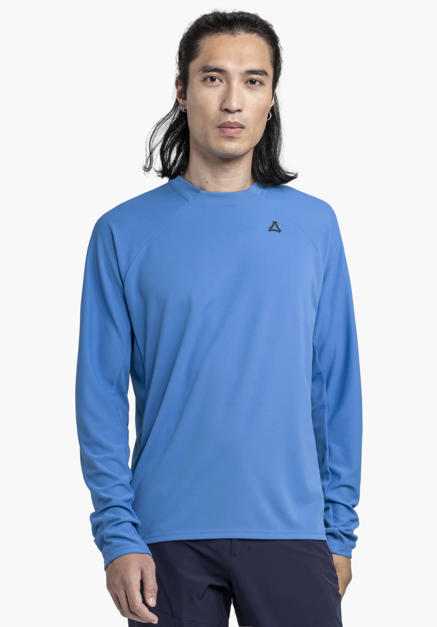 Longsleeve Style Enixa MEN, getragen von einem Model in Frontalansicht. Das blaue Oberteil ist mit dem Schöffel-Logo auf der linken Brust versehen. Das Model steht vor einem neutralen Hintergrund.