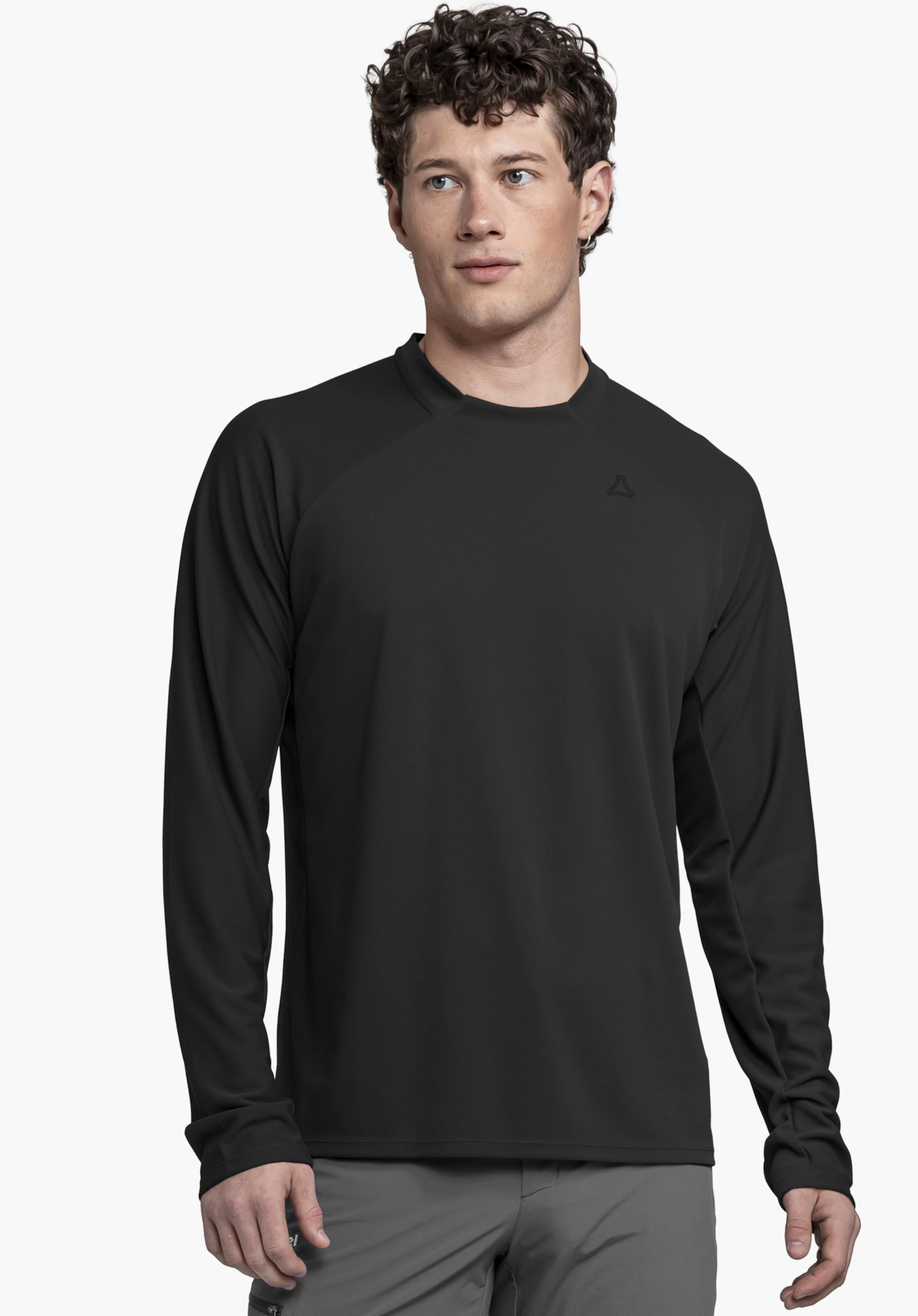Longsleeve Style Enixa MEN on a model standing frontally and looking slightly to the side. The black top features the Schöffel logo on the left chest in front of a neutral background.
