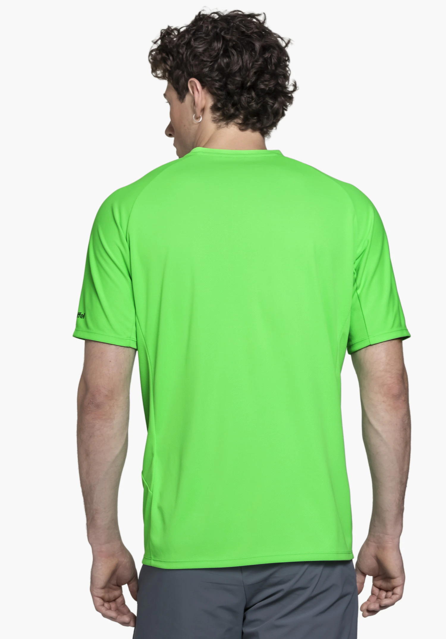 T Shirt Style Enixa MEN in leuchtendem Grün präsentiert sich hier in der Rückenansicht. Das Modell steht vor einem neutralen Hintergrund und zeigt das dezent platzierte Schöffel-Logo auf dem Ärmel, ideal für aktive Tage im Freien.