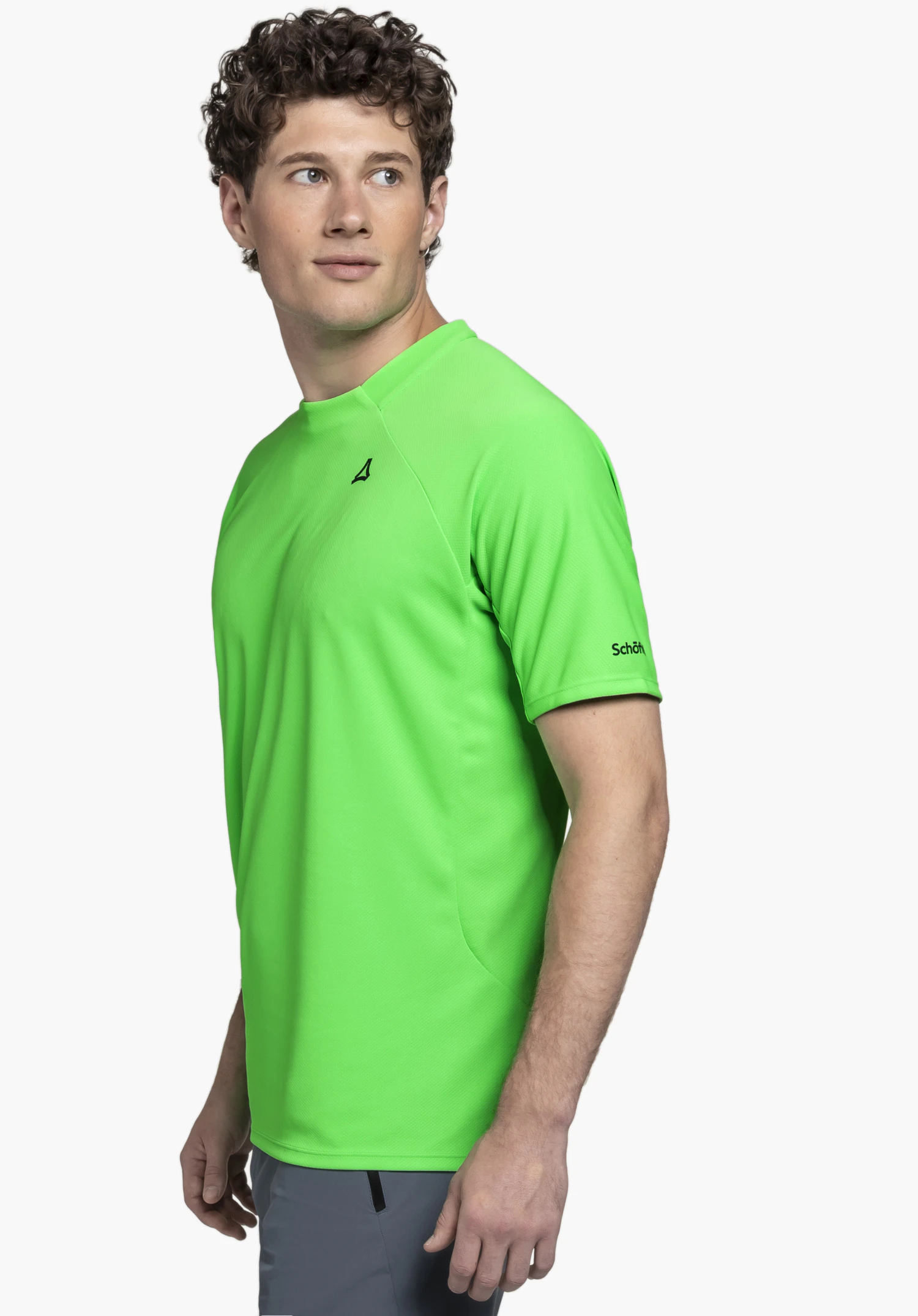 T Shirt Style Enixa MEN in leuchtendem Grün präsentiert vor einem neutralen Hintergrund. Der männliche Körper ist im Halbprofil zu sehen, wobei das subtile Schöffel-Logo am Ärmel sowie das Logo auf der Brustpartie deutlich hervorstechen.