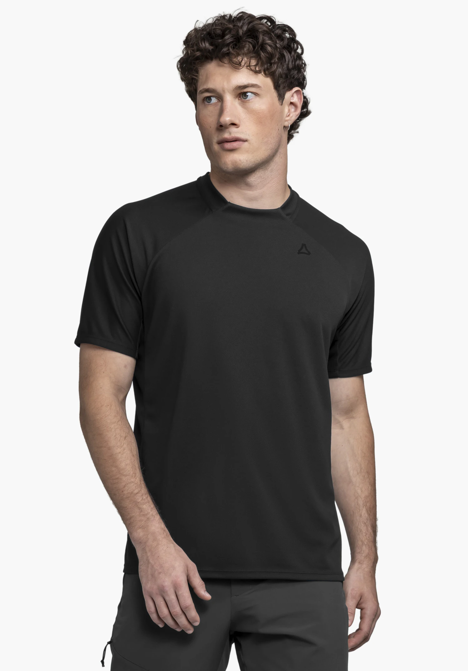 T Shirt Style Enixa MEN in Schwarz: Das Model präsentiert das Shirt vor einem neutralen Hintergrund und blickt leicht nach links. Das dezente Schöffel-Logo ist im Brustbereich sichtbar, während die Passform den sportiven Schnitt des T-Shirts betont.