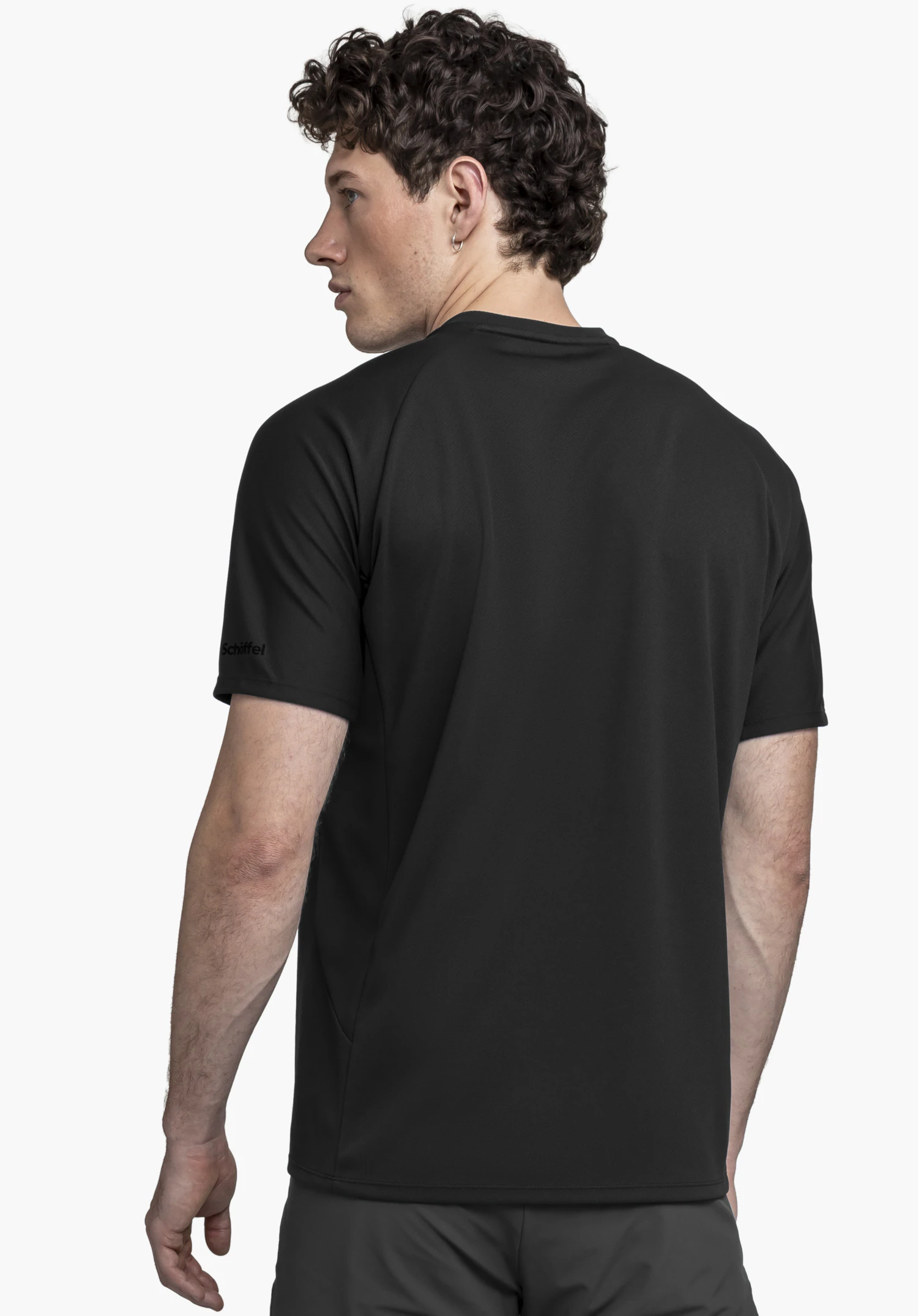 T Shirt Style Enixa MEN: The model is seen from the back against a neutral background, showcasing the shirt in black. The subtle Schöffel logo is clearly visible on the right sleeve.