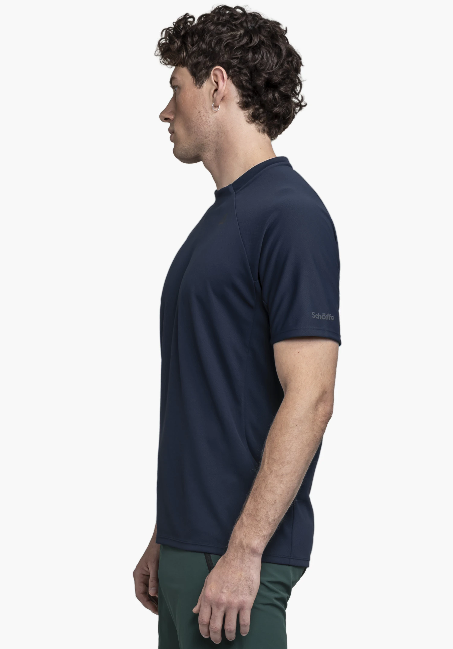 T Shirt Style Enixa MEN en bleu. Le mannequin pose de profil sur un fond neutre pour mettre en valeur la coupe. Le logo Schöffel est discrètement visible sur la manche.