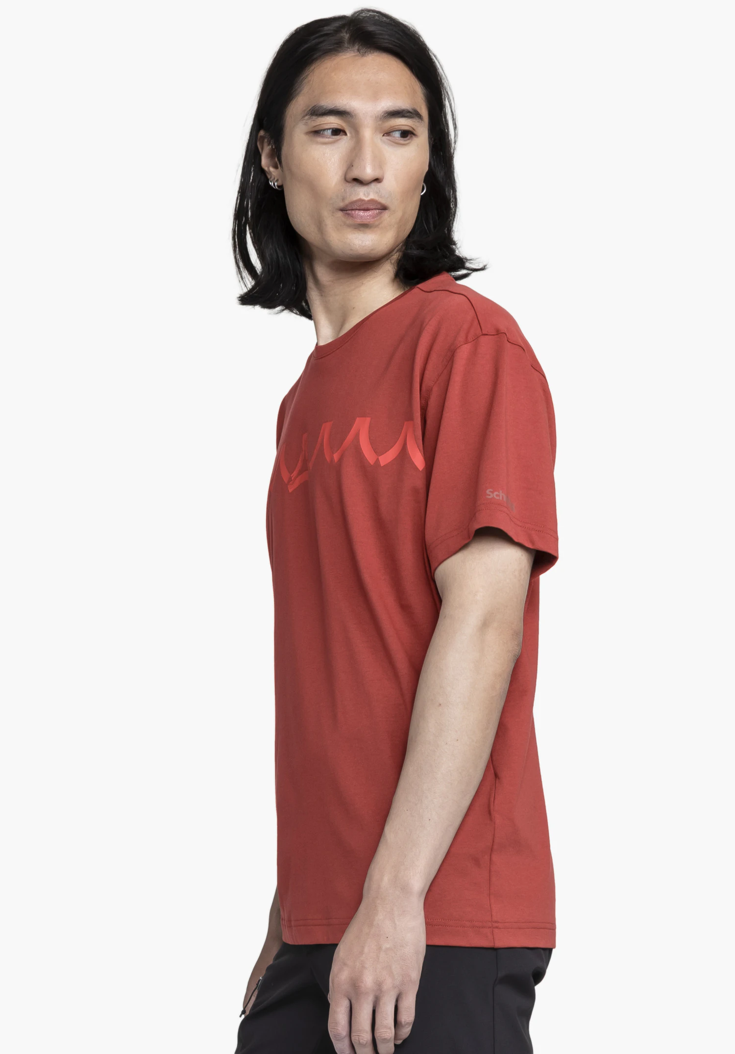 T Shirt Style Elmori MEN in red. A male model stands sideways in front of a neutral background, showcasing the t-shirt. The Schöffel logo is subtly visible on the sleeve.