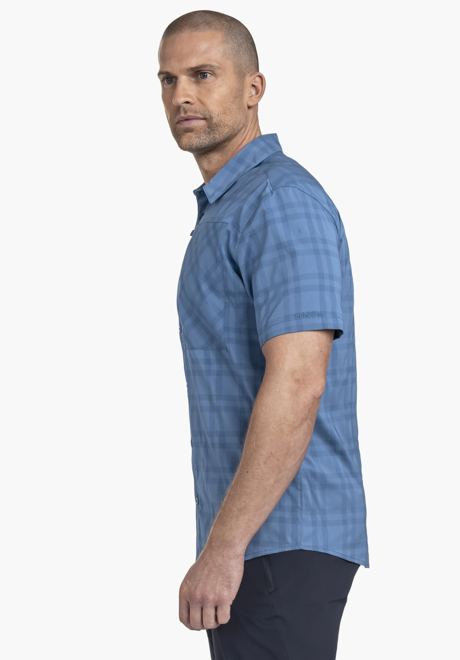 Shirt Style Frolya MEN. A model stands sideways wearing the blue short-sleeved shirt with a visible Schöffel logo on the sleeve against a neutral background.