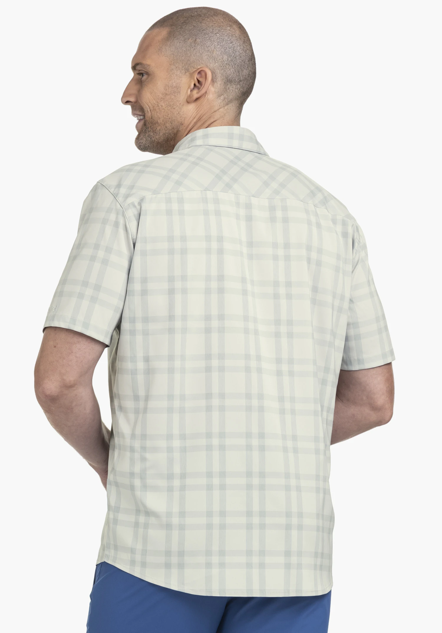 Shirt Style Frolya MEN vu de dos devant un fond neutre. L'homme porte cette chemise grise avec un logo Schöffel discret sur la manche et regarde légèrement par-dessus l'épaule.