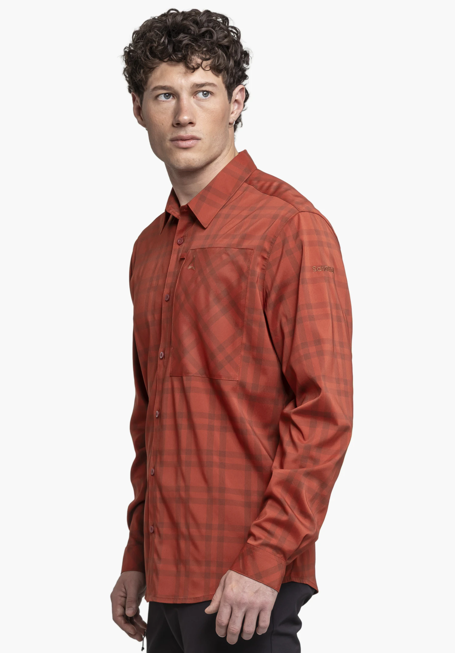 Shirt Style Fraris MEN in red. A model stands in a side profile position against a neutral background, showcasing the checked shirt with the subtle Schöffel logo on the sleeve.
