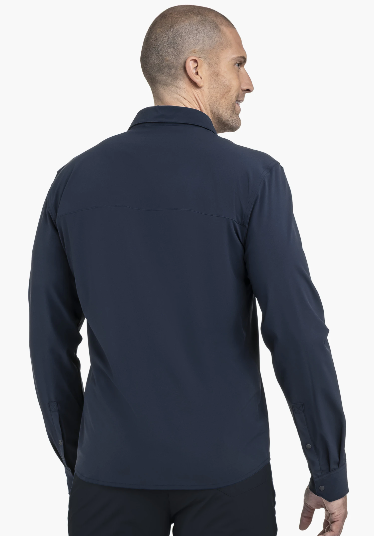 Shirt Style Dunajec MEN en bleu présenté de dos. Le modèle pose devant un arrière-plan neutre, mettant en valeur la coupe de cette chemise à manches longues, avec le logo Schöffel discret visible sur la manche.