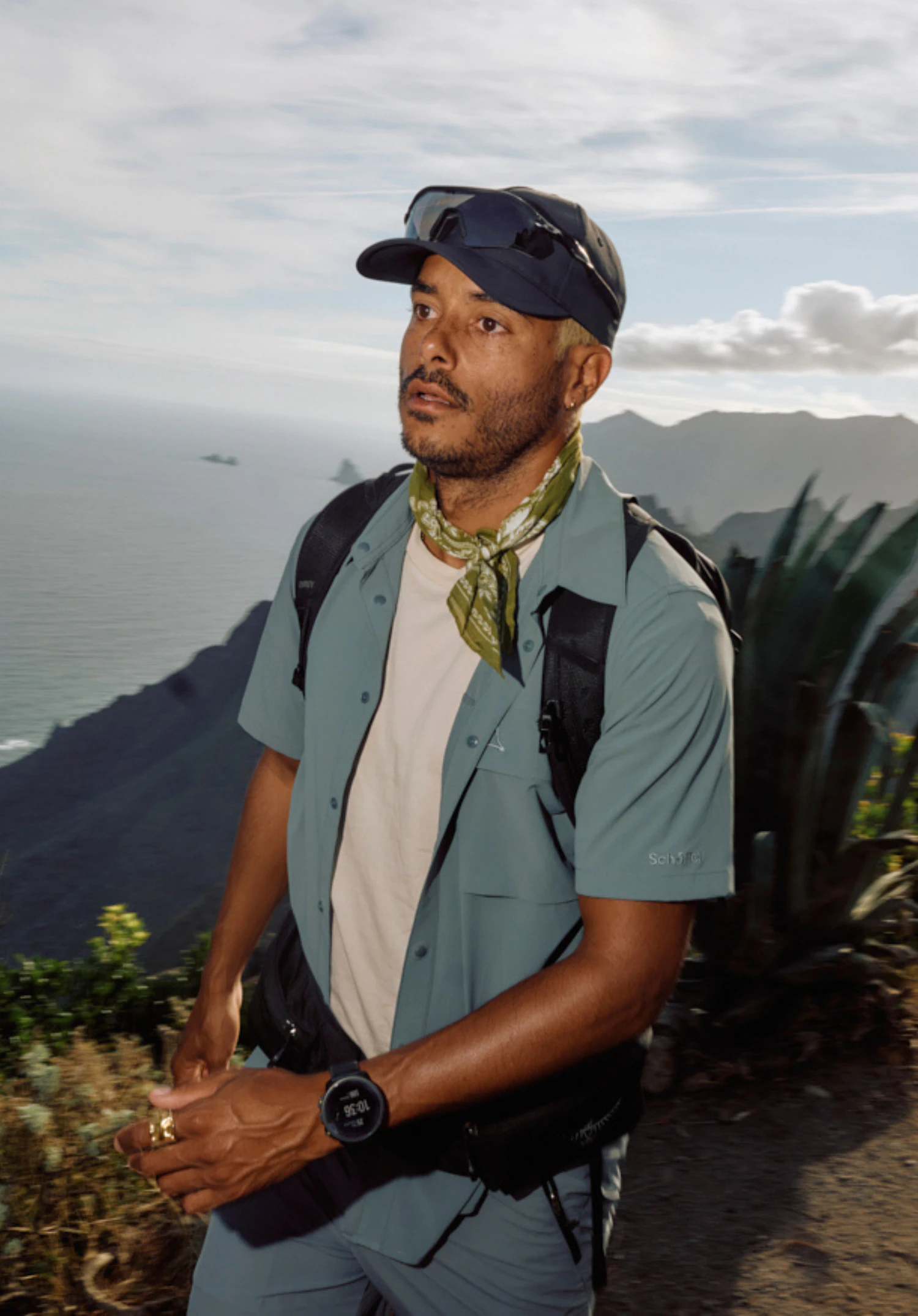 Shirt Style Dooser MEN in grey. A model wearing the short-sleeved shirt stands against a neutral background, looking slightly to the side. The clean design is complemented by the subtle Schöffel logo on the chest pocket.