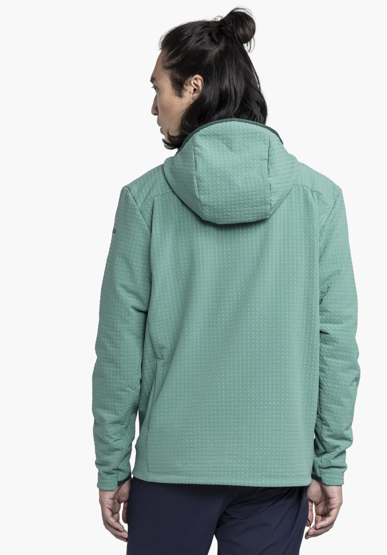 Fleece Hoody Style Enixa MEN porté par un mannequin vu de dos. On aperçoit la texture gaufrée distinctive du sweat à capuche vert et une partie du logo Schöffel sur la manche gauche, présenté sur un fond neutre.