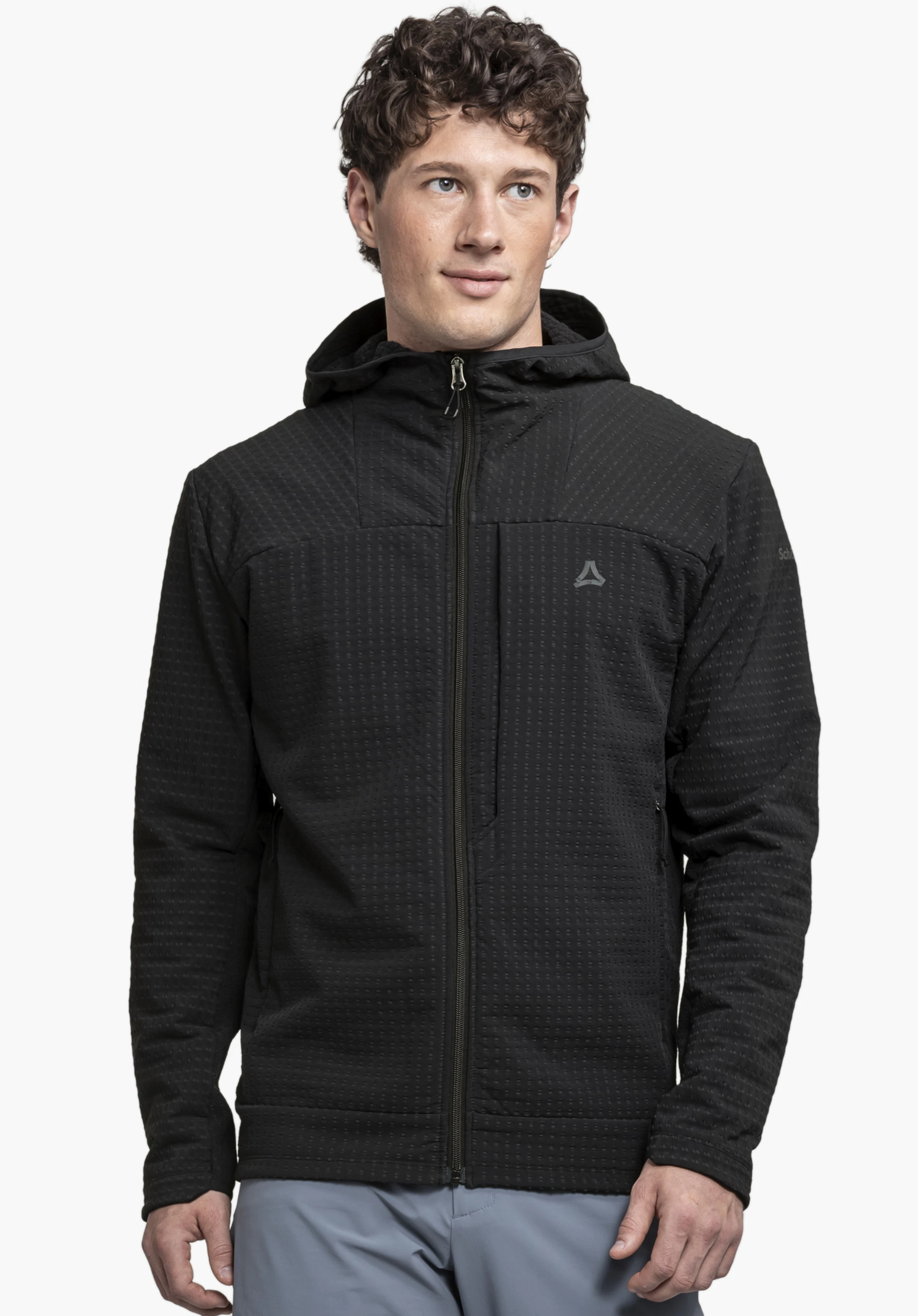 Fleece Hoody Style Enixa MEN on a male model standing facing forward. The zip of the black hoody is closed and the Schöffel logo on the left chest is visible. The image is taken in front of a neutral background.