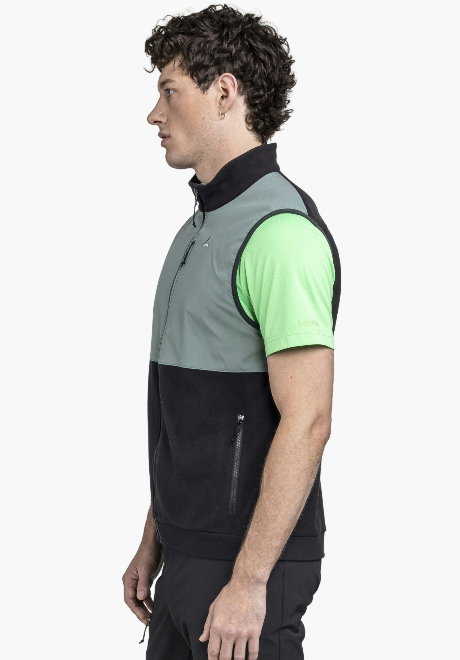 Fleece Vt Style Ash MEN in der Farbe Schwarz. Das Model steht seitlich vor einem neutralen Hintergrund und präsentiert die Weste. Das dezente Schöffel-Logo auf der Brust unterstreicht den hochwertigen Look.