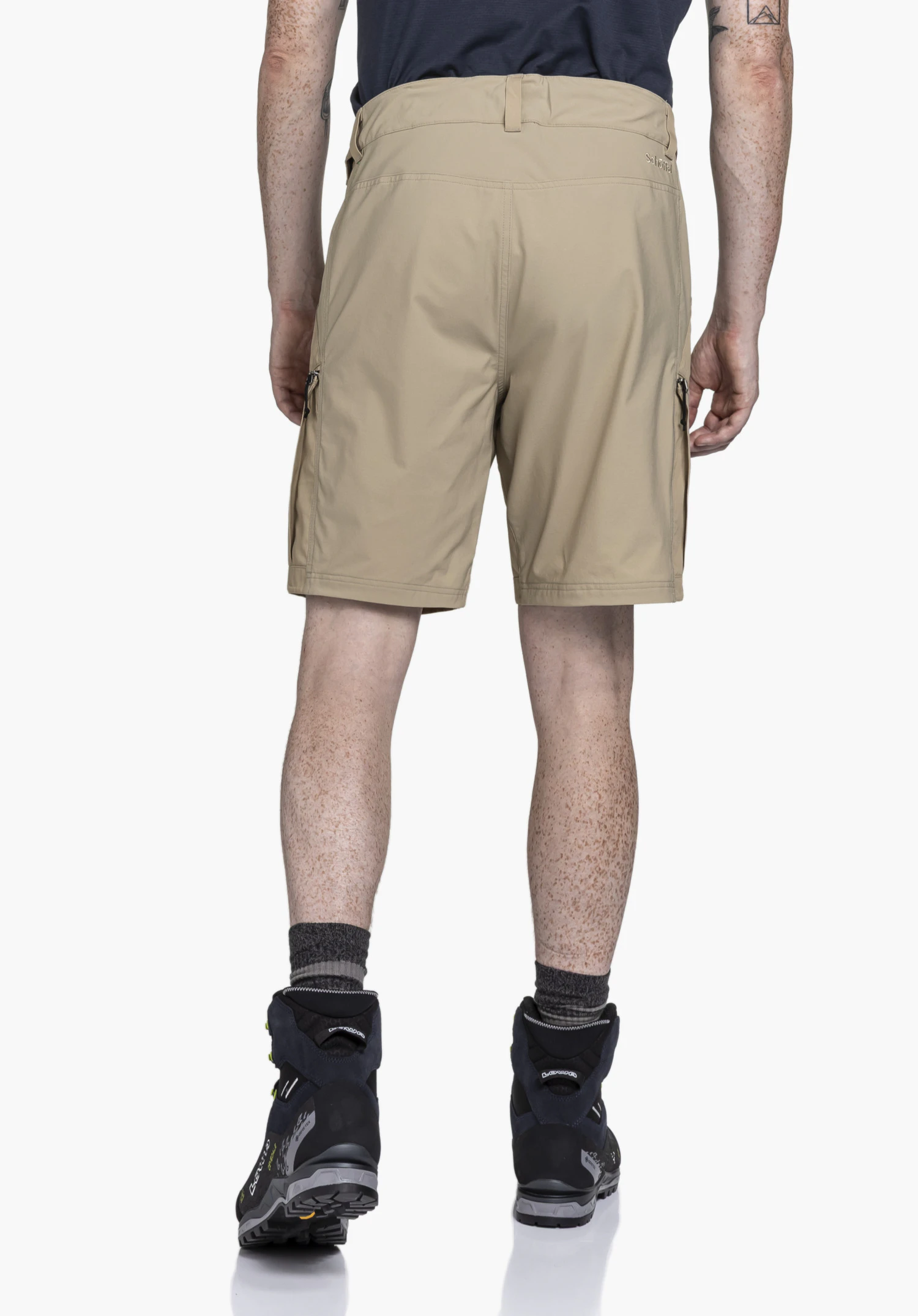Shorts Style Maghera MEN in beige, shown in a rear view on a model against a neutral background. The functional zip pockets on the sides and the Schöffel logo on the back right are visible.