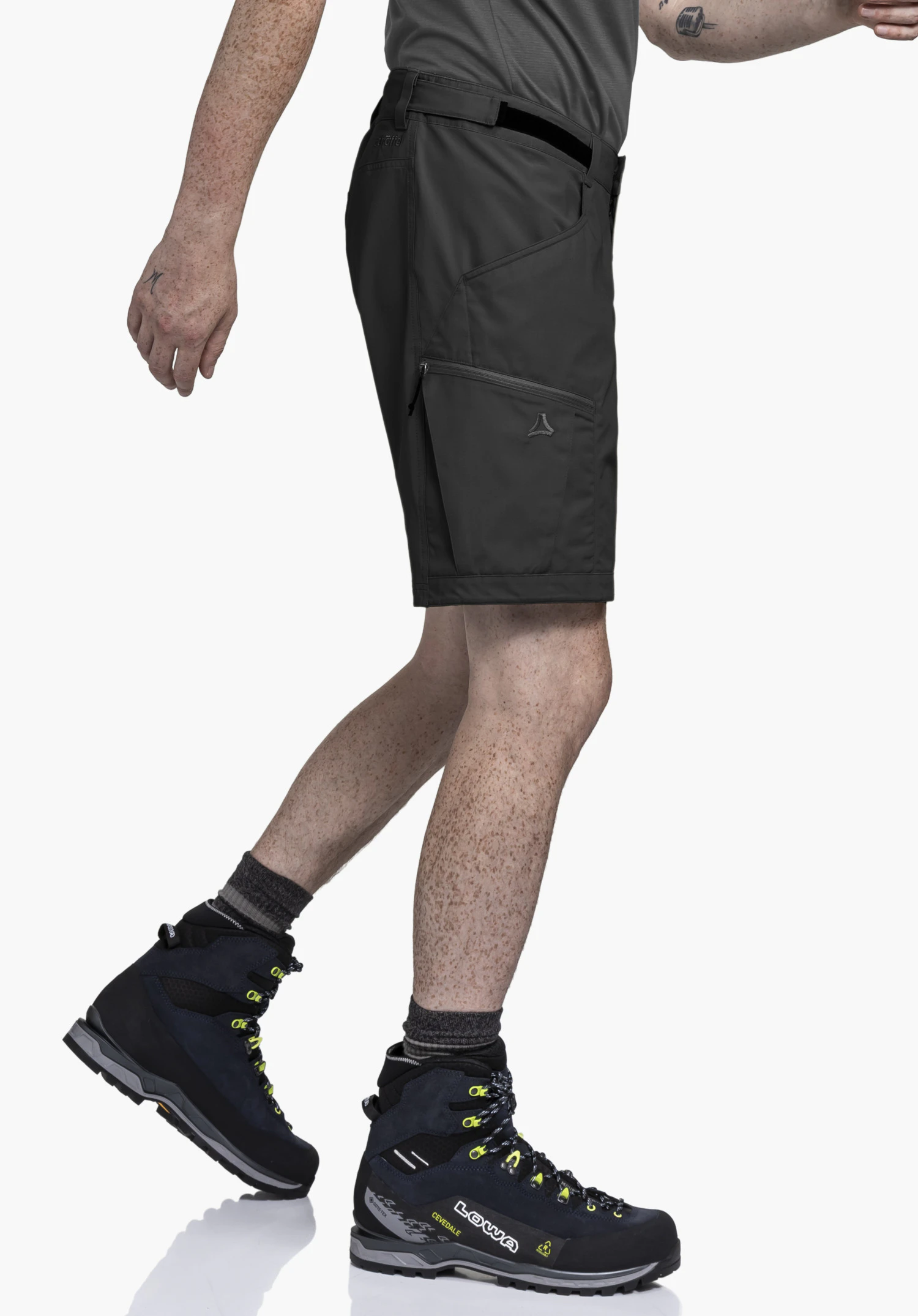 Shorts Style Maghera MEN in black. The model is shown in profile, mid-stride in front of a neutral background. The focus is on the functional fit, highlighting the subtle Schöffel logo on the leg pocket.