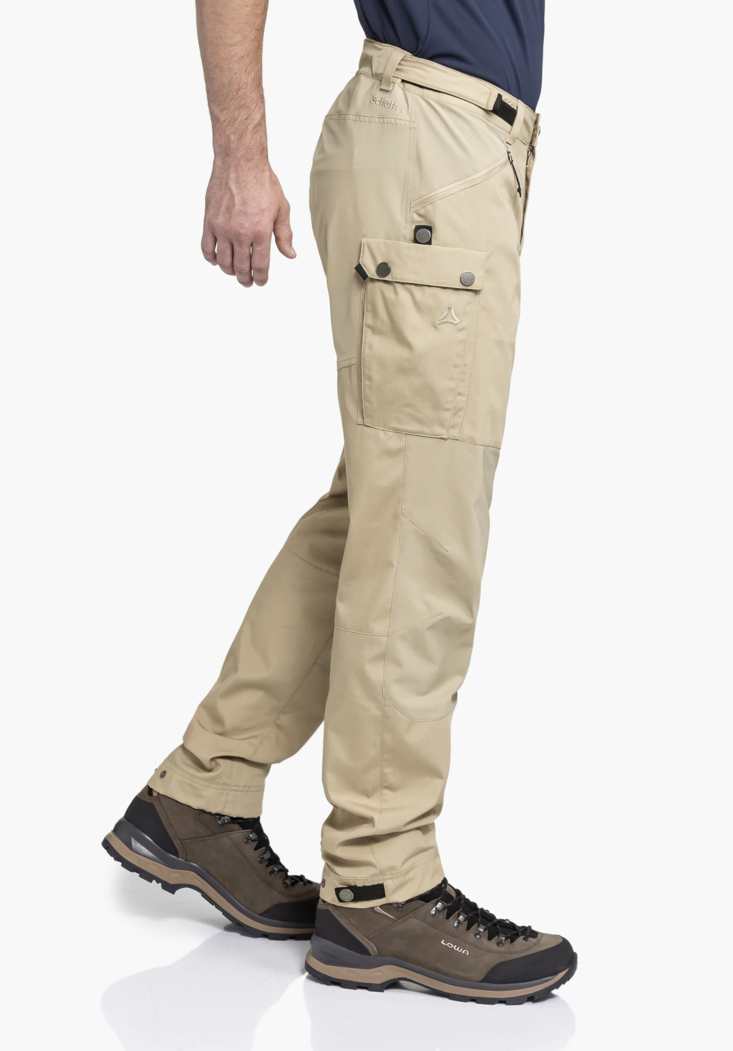Pants Style Maghera MEN in beige. The model is shown in profile against a neutral background, highlighting the functional leg pocket and the subtle Schöffel logo on the thigh, perfect for outdoor adventures.