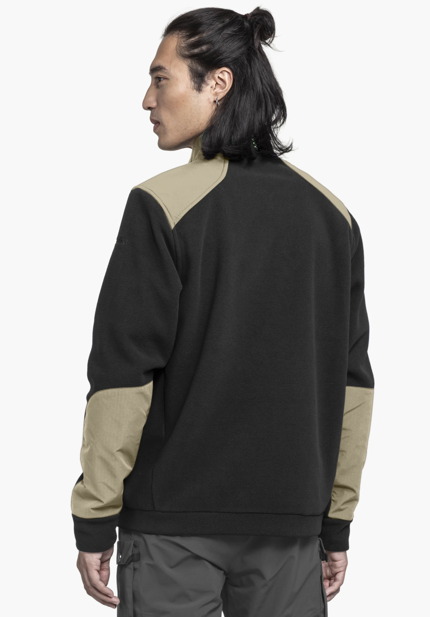 Fleece Jk Style Maghera MEN shown from the back on a model standing sideways. The fleece jacket in black features contrast panels on the shoulders and elbows and a Schöffel logo on the sleeve against a neutral background.