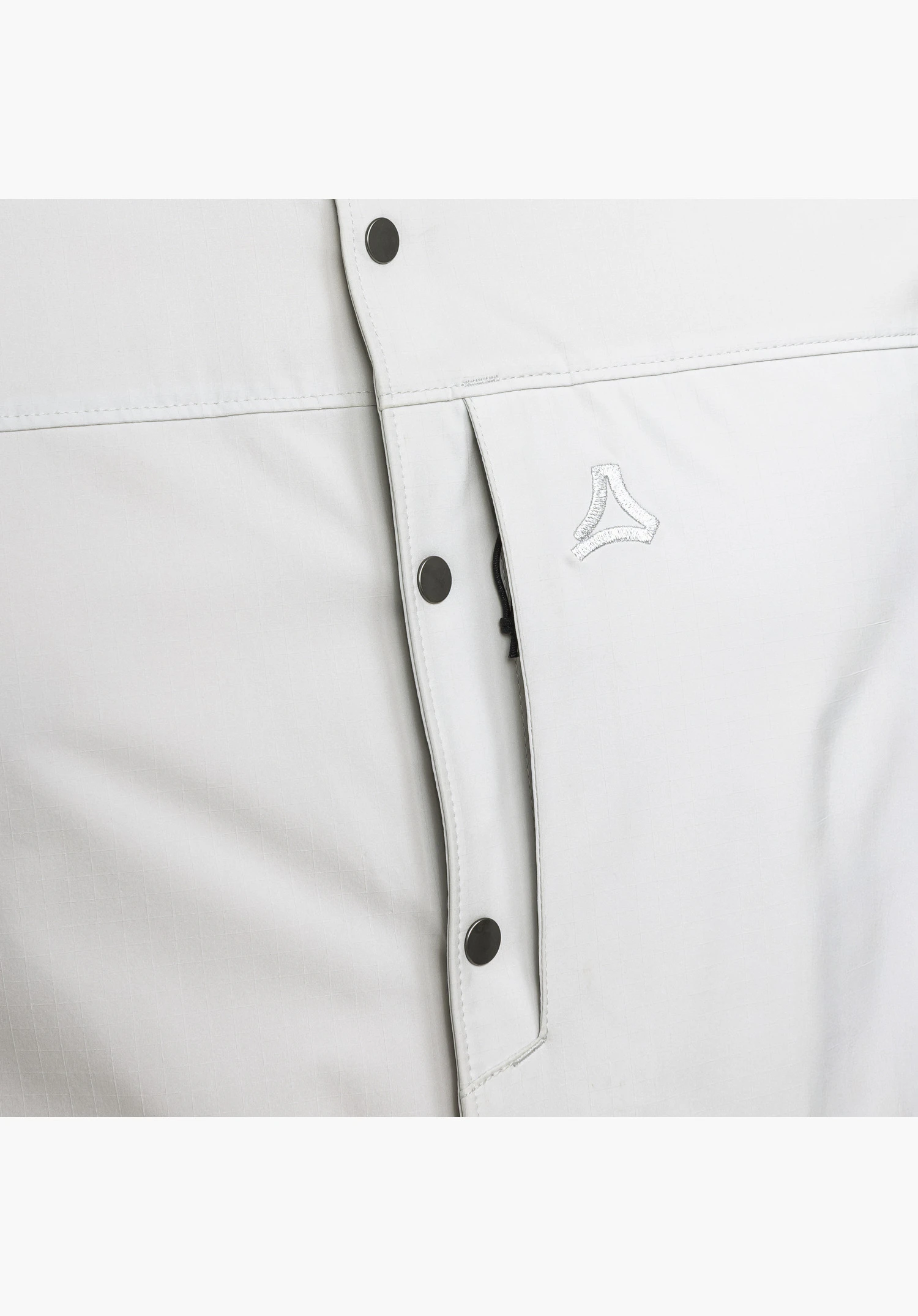 Shirt Style Maghera MEN, focus on the grey fabric texture, dark press studs, a concealed chest pocket with a subtle zip and the embroidered Schöffel-Logo, close-up against a white/neutral background.
