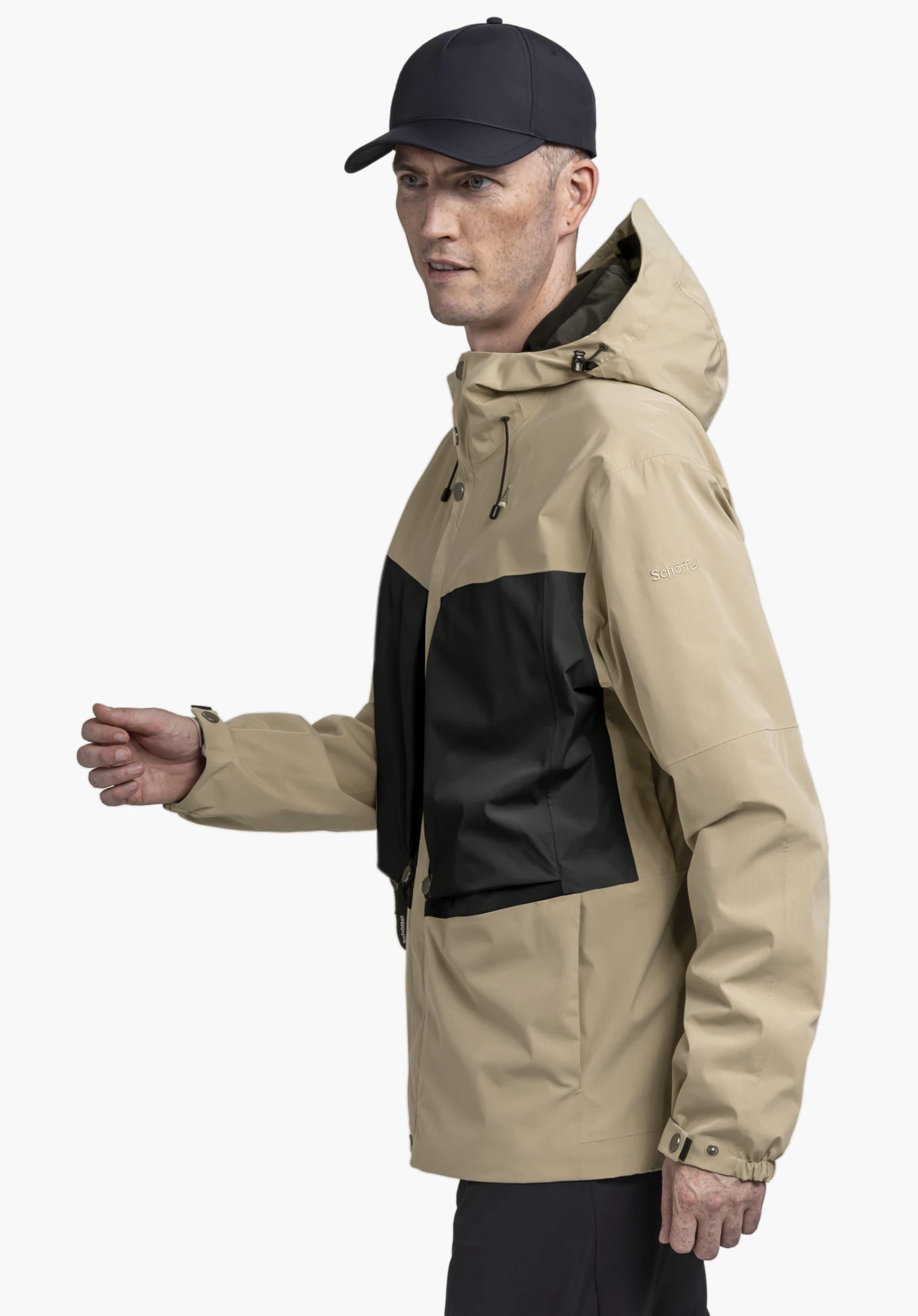 2L Jacket Style Maghera MEN in beige shown on a model standing in a side profile pose. The jacket is presented against a neutral background, with the Schöffel logo clearly visible on the upper sleeve.