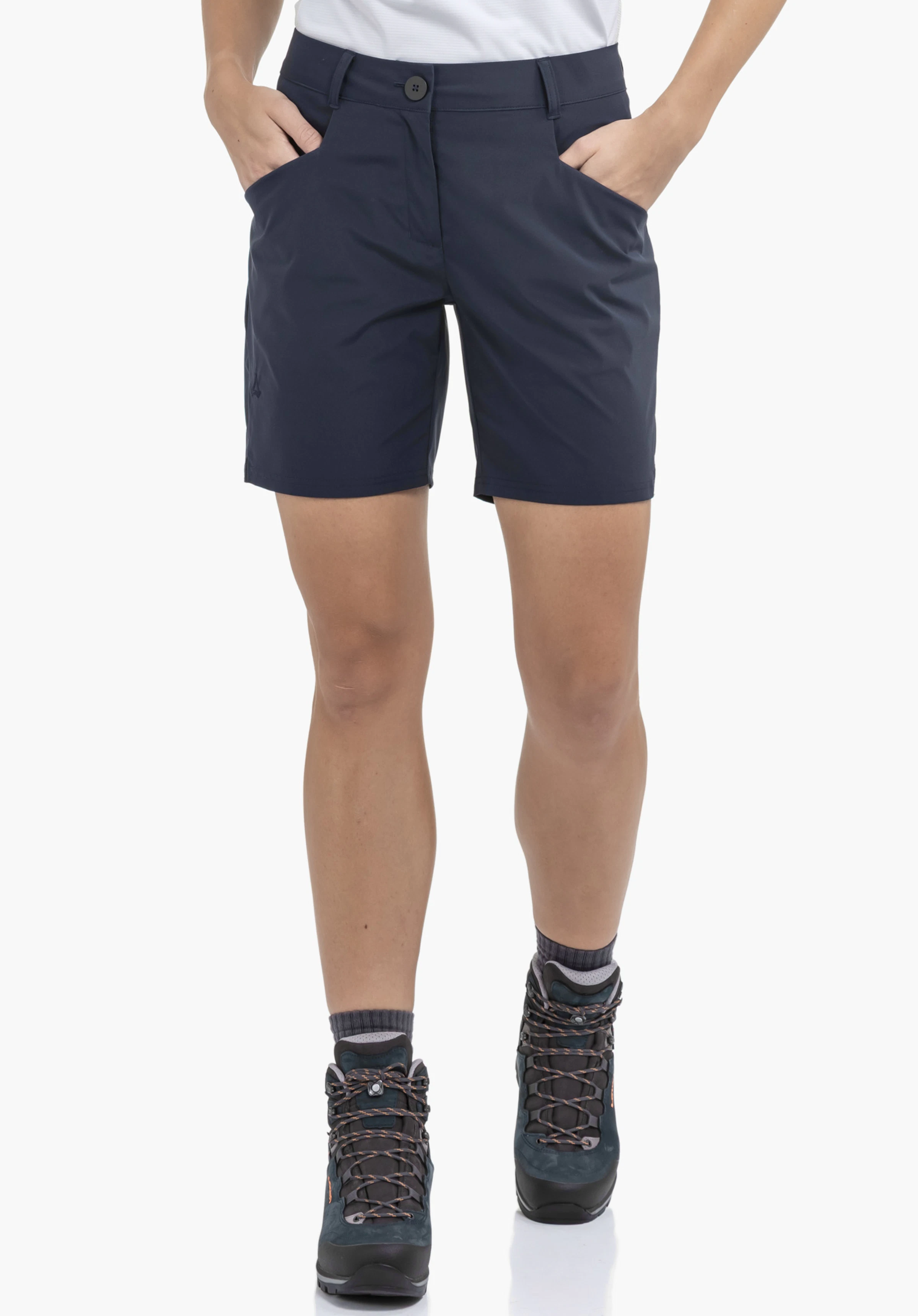 CIRC Shorts Style Smue WMN worn by a model standing front on with both hands in the pockets of the blue shorts. A subtle Schöffel logo is visible on the right leg, presented against a neutral background.