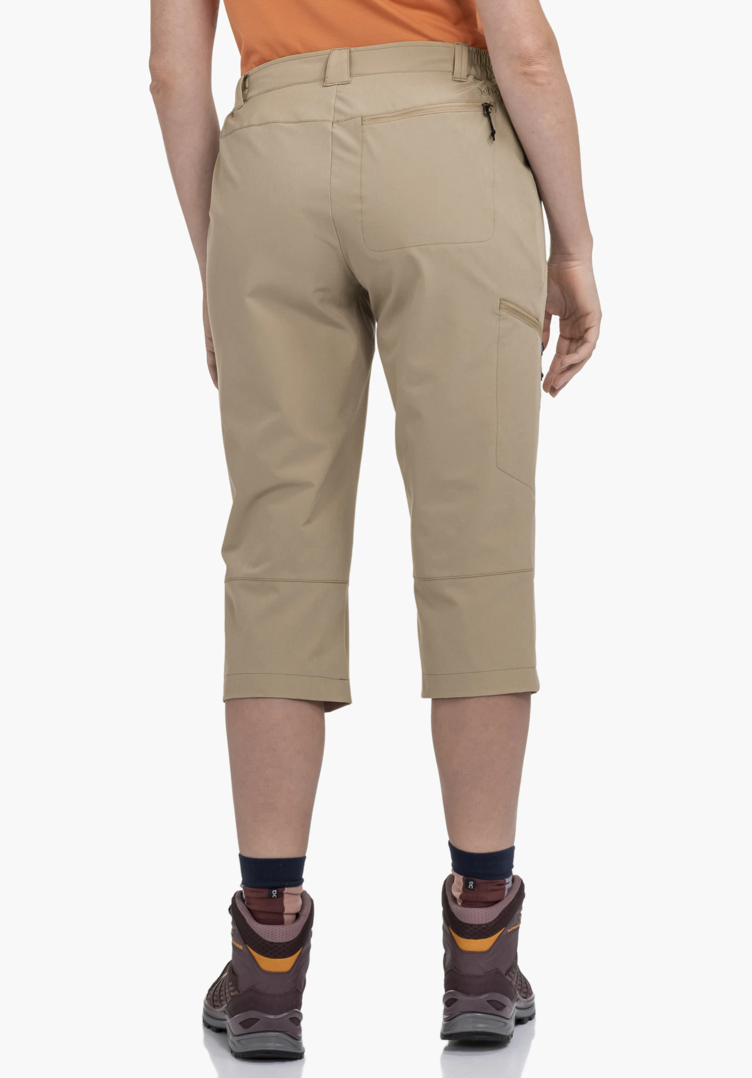 Pants Style Chavuma WMN in Beige in der Rückenansicht an einem Model vor neutralem Hintergrund mit sichtbarem Schöffel-Logo am hinteren Hosenbund.